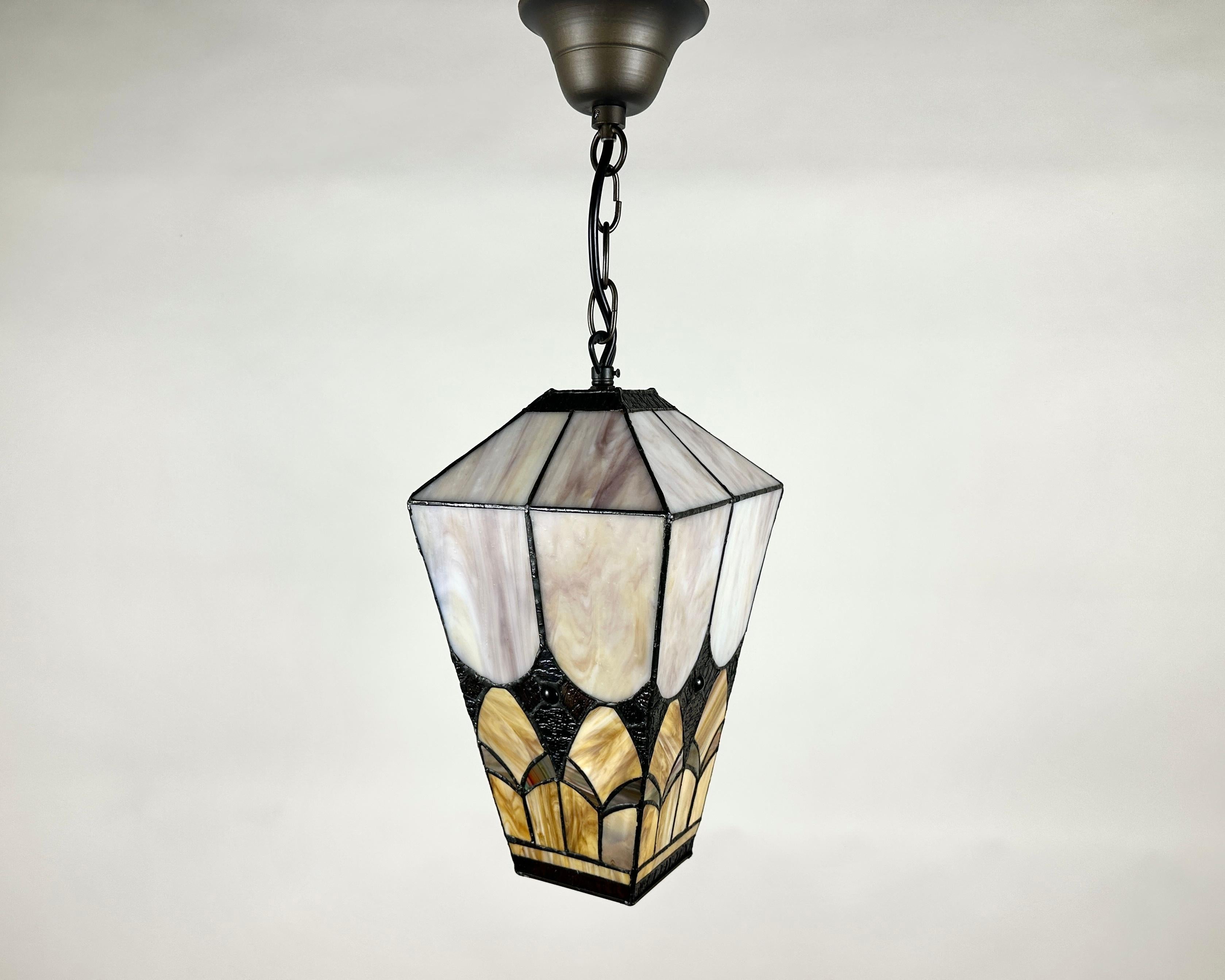 Vintage French Tiffany Style Lantern 1950s Amber Glass

Vintage lantern, crafted in France circa 1950. Designed in the captivating Tiffany style, this piece features a beautifully crafted lampshade with intricate patterns, likely in a warm amber or