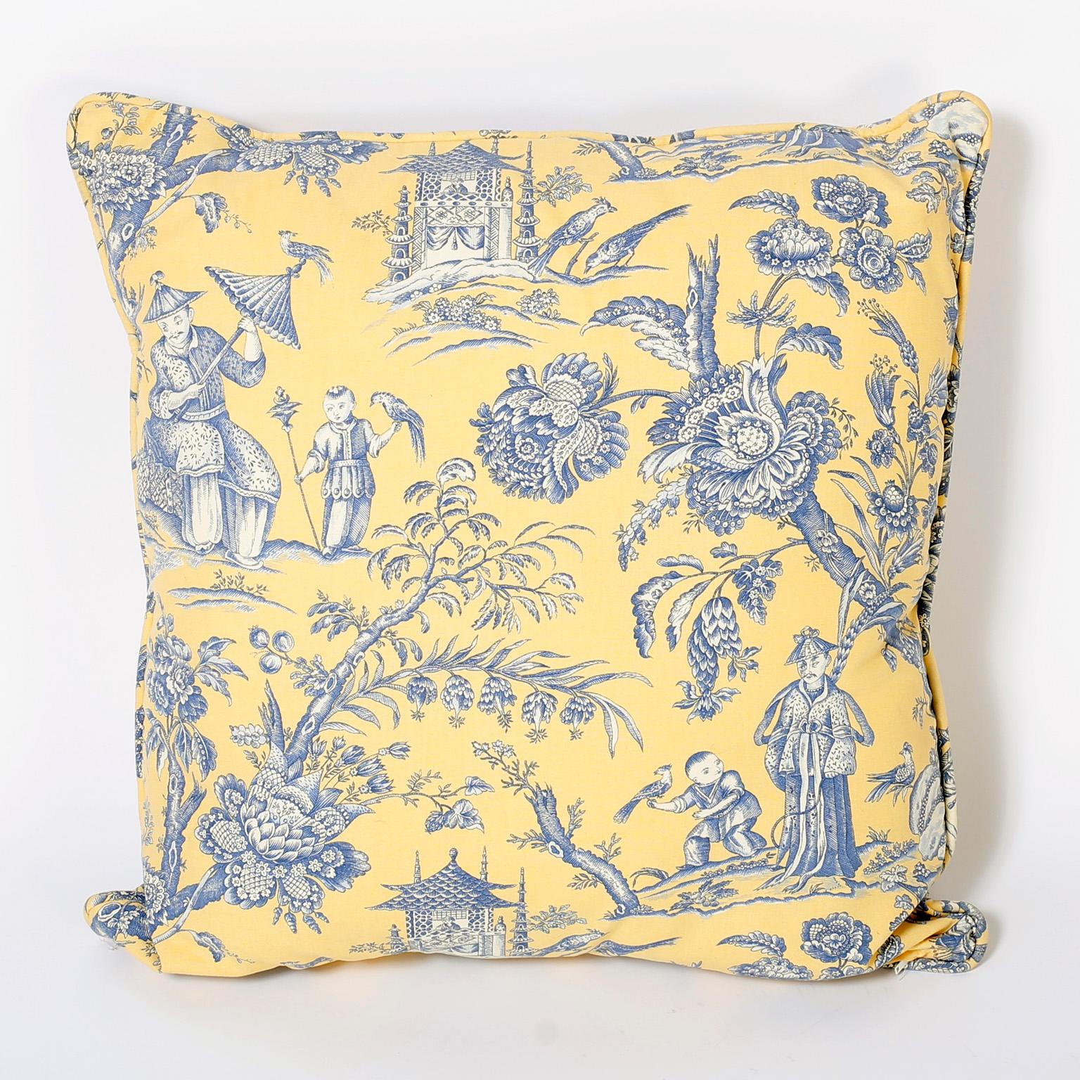 Classical chinoiserie French toile style linen pillows with blue figures and flowers over a yellow background. Discreet zippers in the seam.