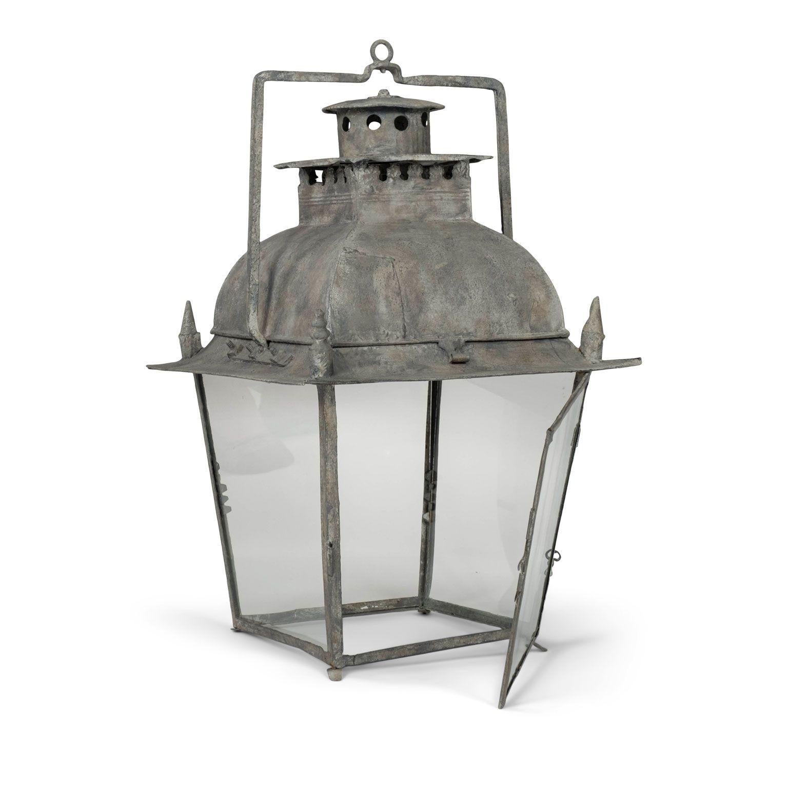 French tole and glass lantern dating to 19th century. Four-sided iron frame, tole top and glass paneled sides. Not wired for electricity, but can be wired, or fitted for usage with gas, for an additional cost. Includes chain and canopy (listed