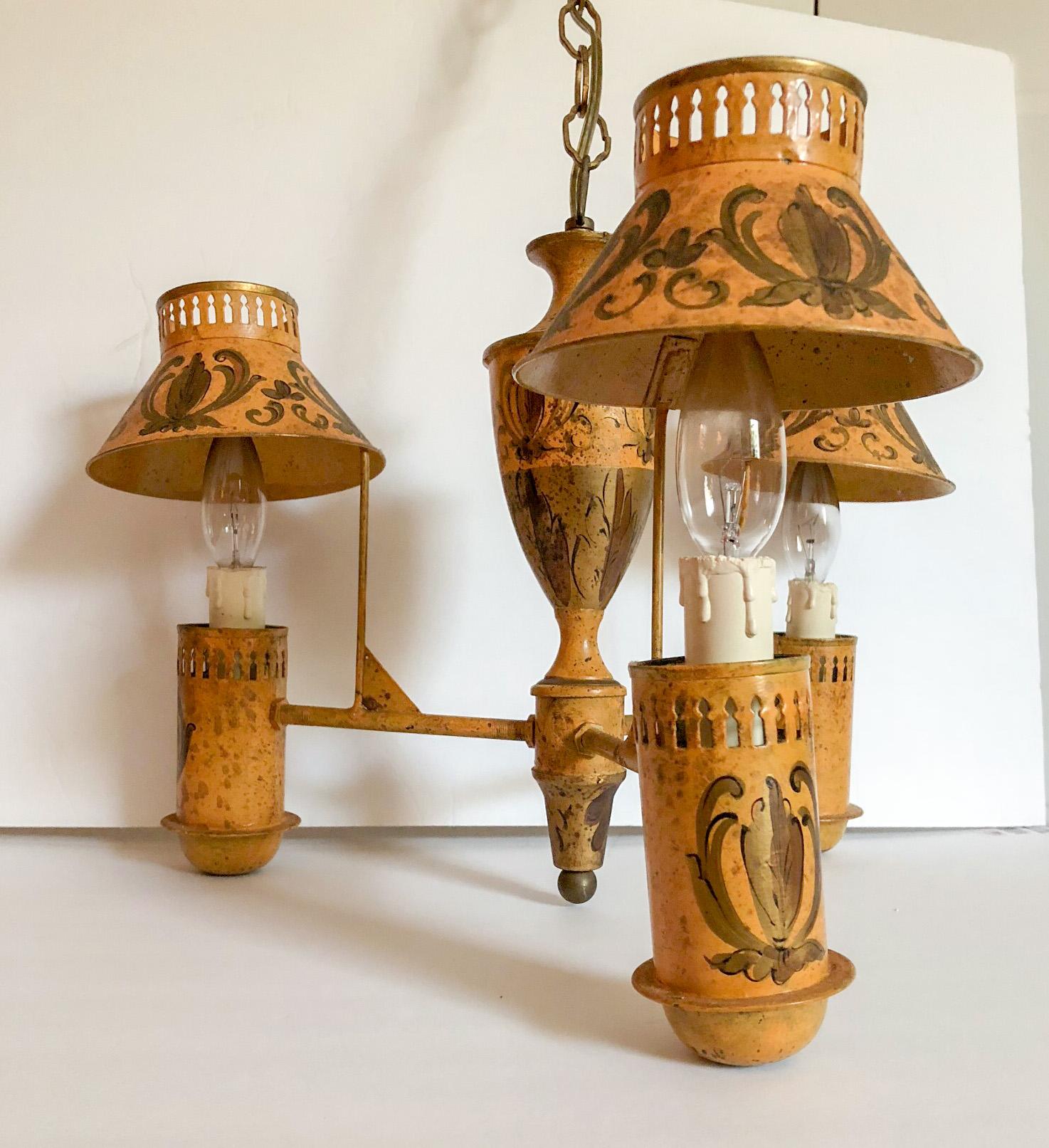 A wonderful tole painted mustard yellow French chandelier with three arms and bouillotte pierced shades. Chandelier appears to have been candle lit at one time and is decorated with hand painted gold ornamentation. While not original, the gold