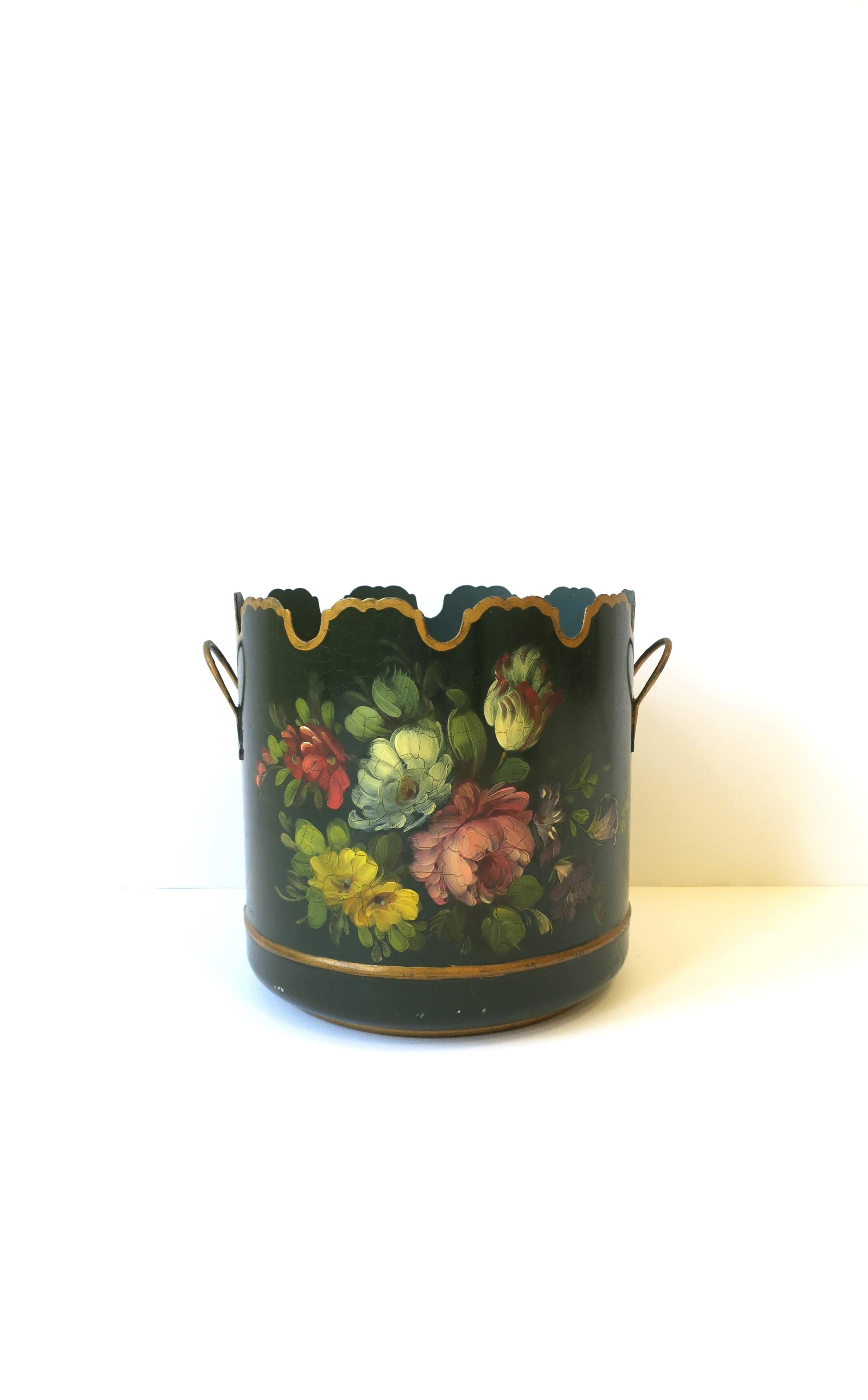 A French Tôle dark green and gold Jardinière Cachepot with hand-painted floral design and scalloped edge, circa early-20th century, France. Piece, dark green, has hand-painted floral design on front, gold scalloped edge around, handles with gold