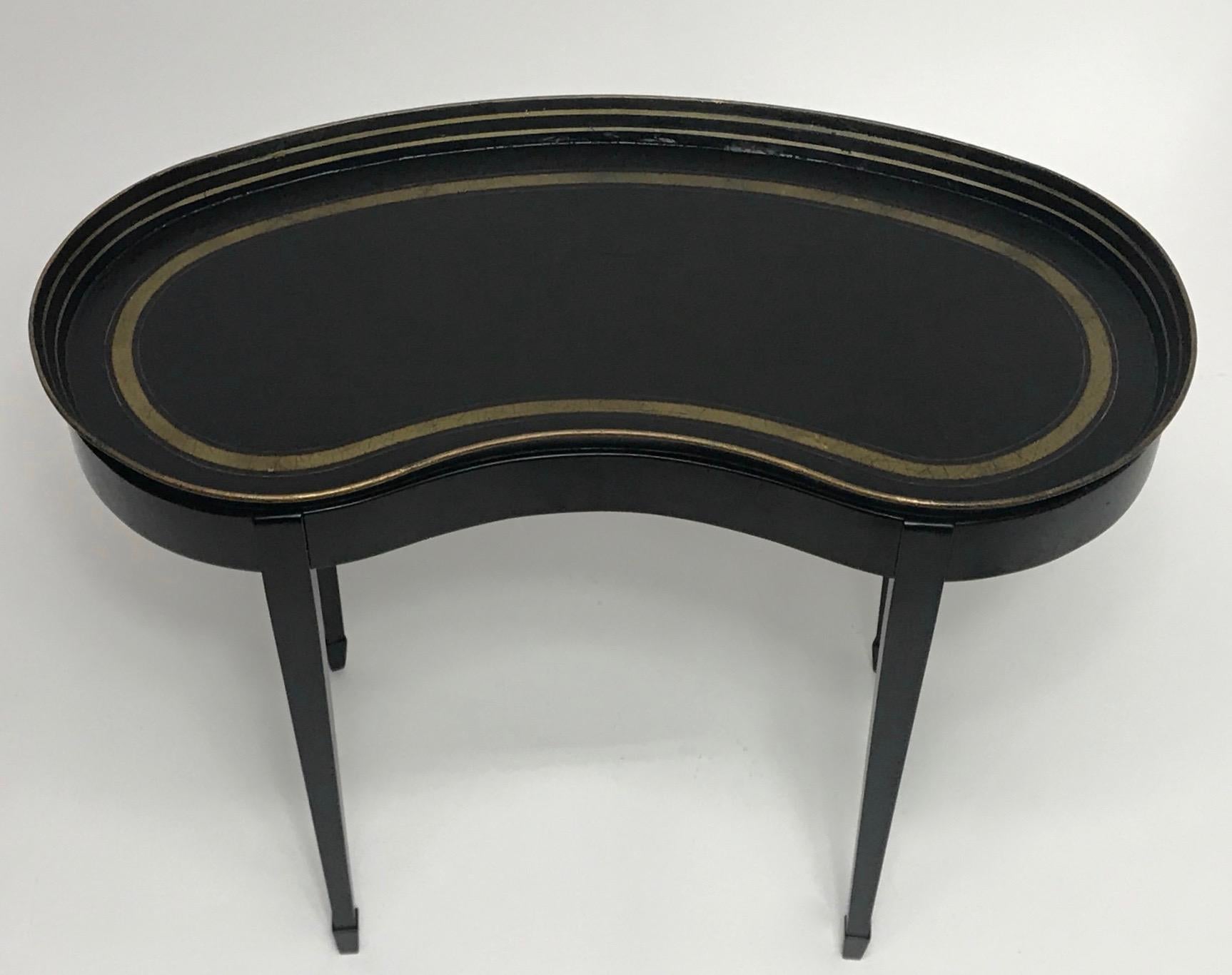 An unusual kidney shape black papier mâché tray with hand painted gilt decoration on a custom made black lacquered stand,
Late 19th-early 20th century, France.


   