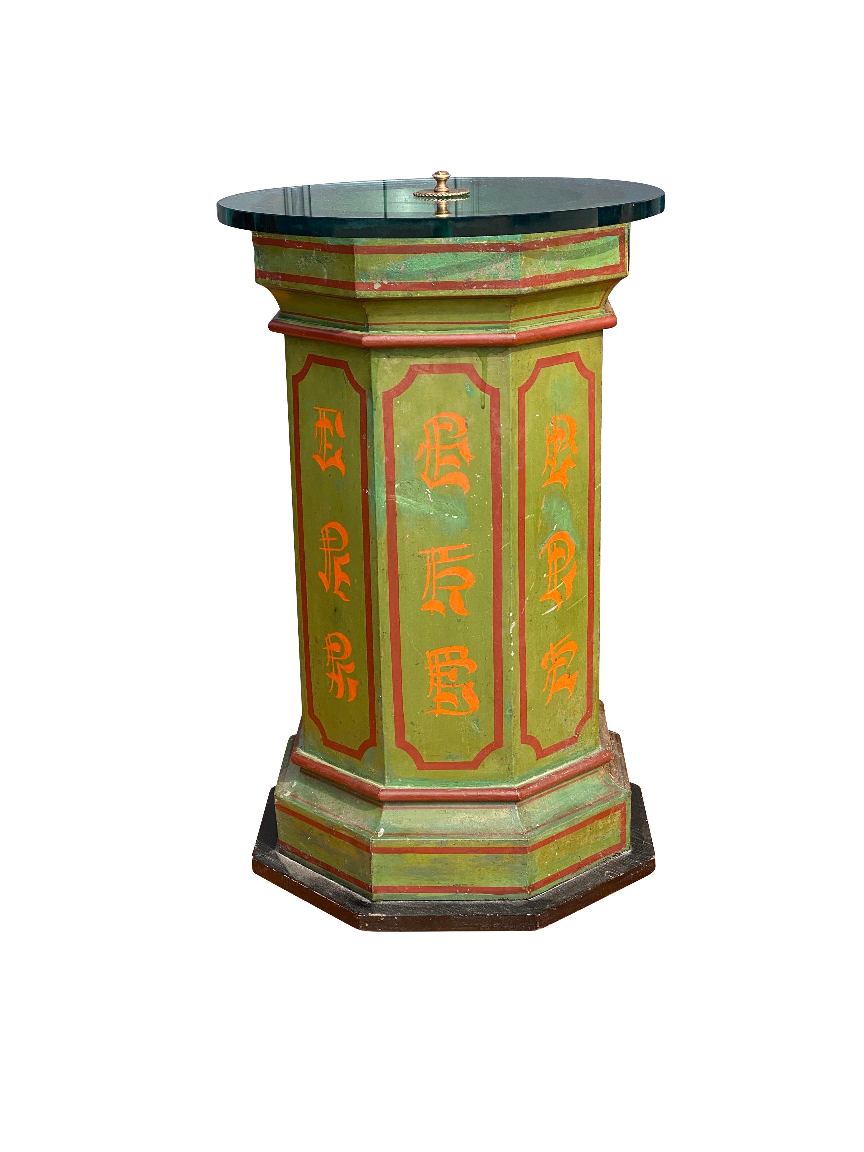 With glass circular top over a painted tole hexagonal column in a Asian design.