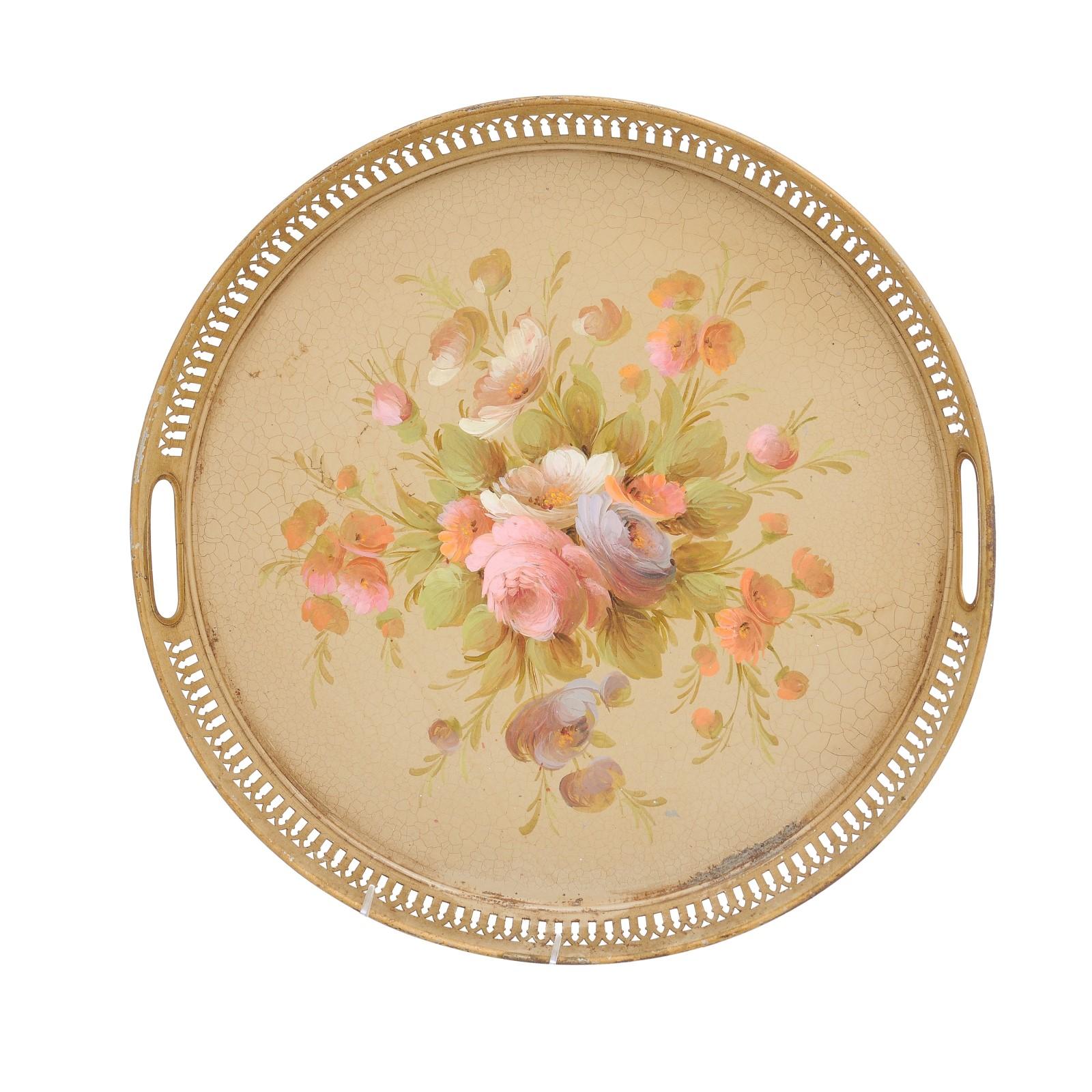 A French round tôle tray from the 20th century with hand-painted décor depicting a bouquet of roses, and pierced gallery. Created in France during the 20th century, this tôle tray features a circular shape surrounded by a pierced gallery adorned