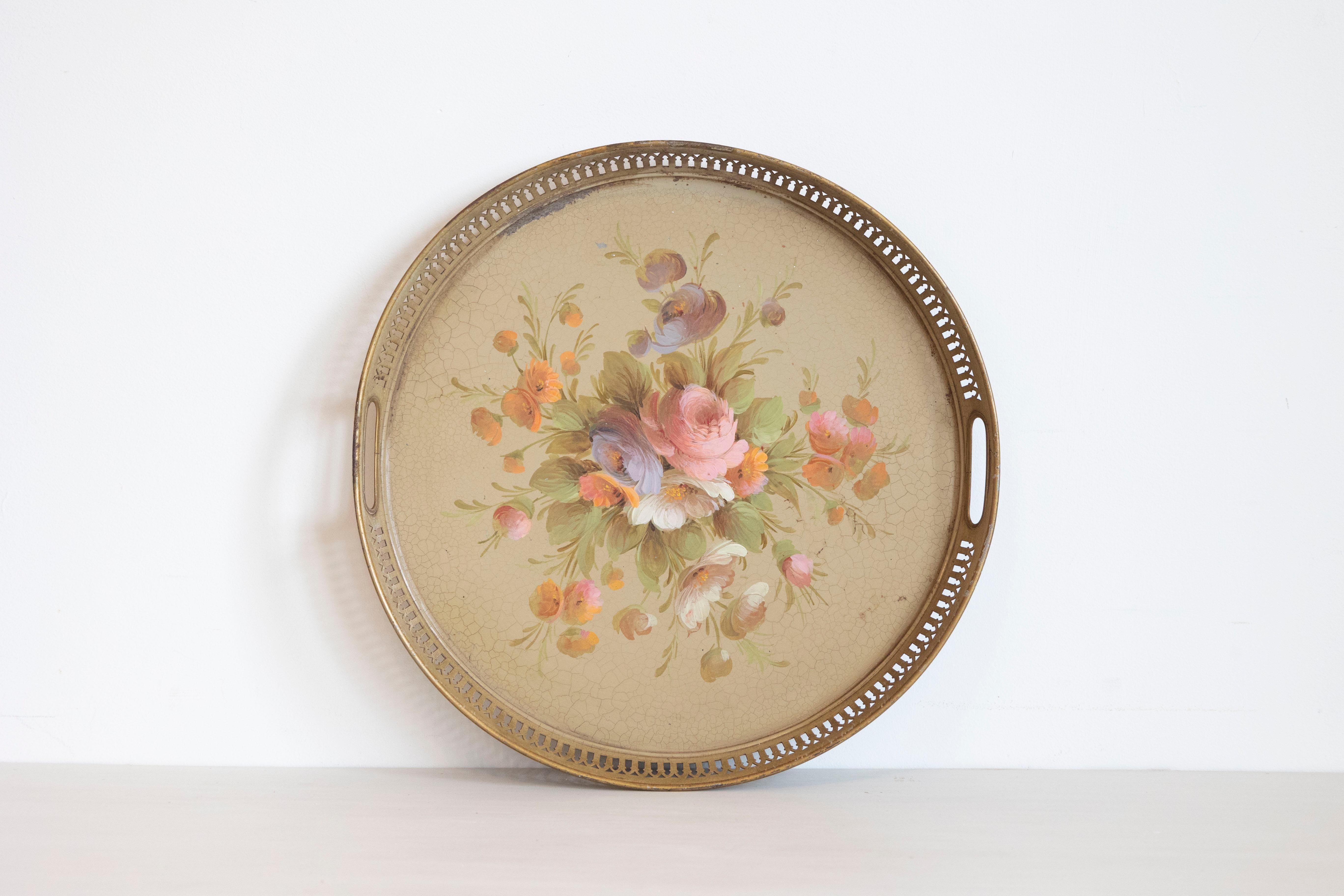 Bandeja tôle redonda francesa del siglo XX con decoración pintada a mano que representa un ramo de rosas, y galería calada. Creada en Francia durante el siglo XX, esta bandeja tôle presenta una forma circular rodeada por una galería calada adornada