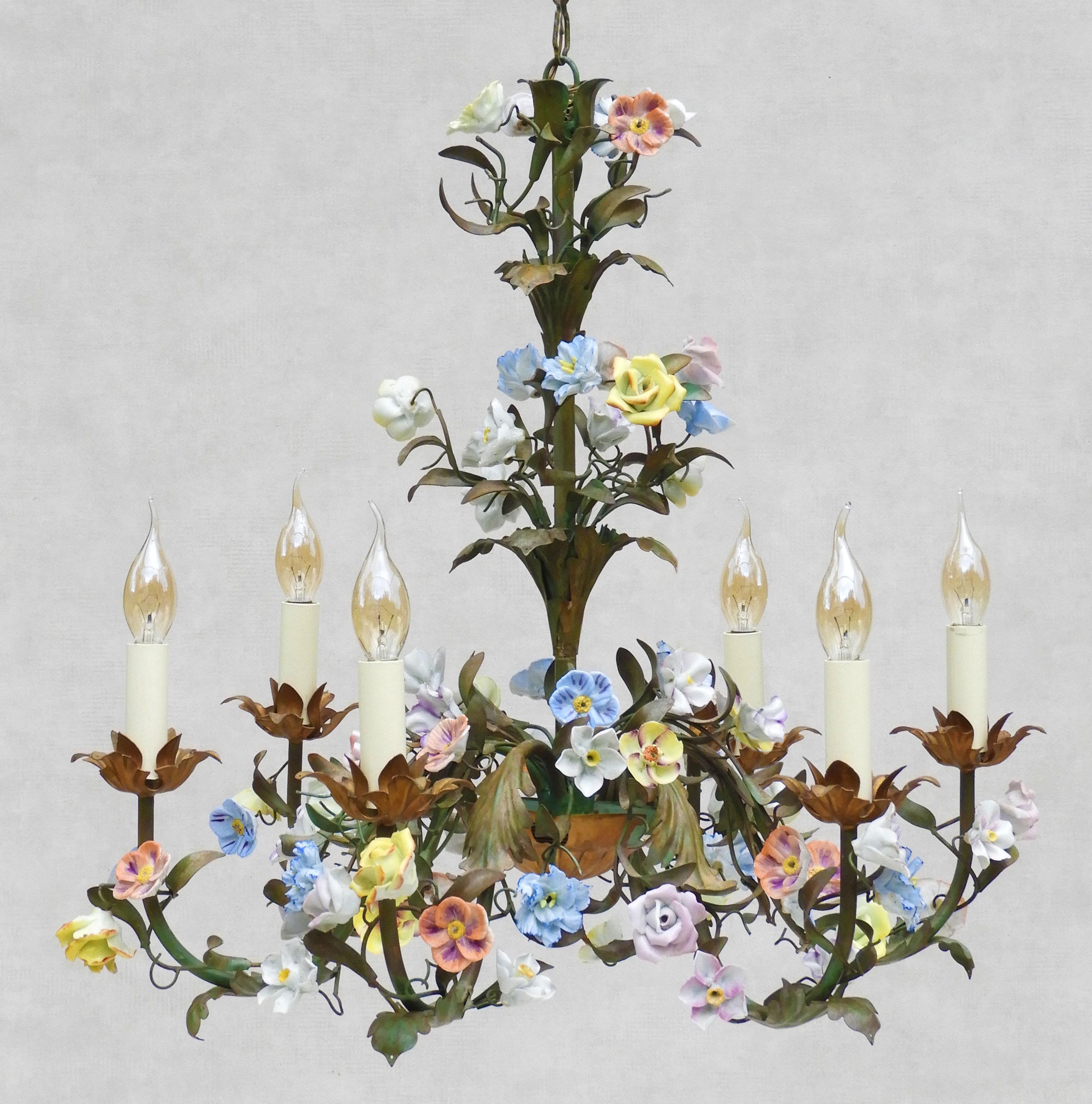 A beautiful French mid-century floral chandelier with an abundance of hand-crafted porcelain flowers and six 'faux' candle lights, all nestling amongst green and gold scrolling tôle foliage.
In great vintage condition, completely rewired with all