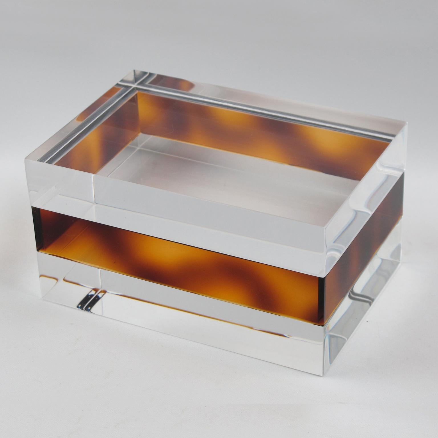 Lovely 1970s French Lucite lidded box. Transparent and faux-tortoiseshell (tortoise) colors paired with a geometric rectangular shape have built a gorgeous design. There is no visible maker's mark.
Measurements: 6.69 in. wide (17 cm) x 4.50 in.