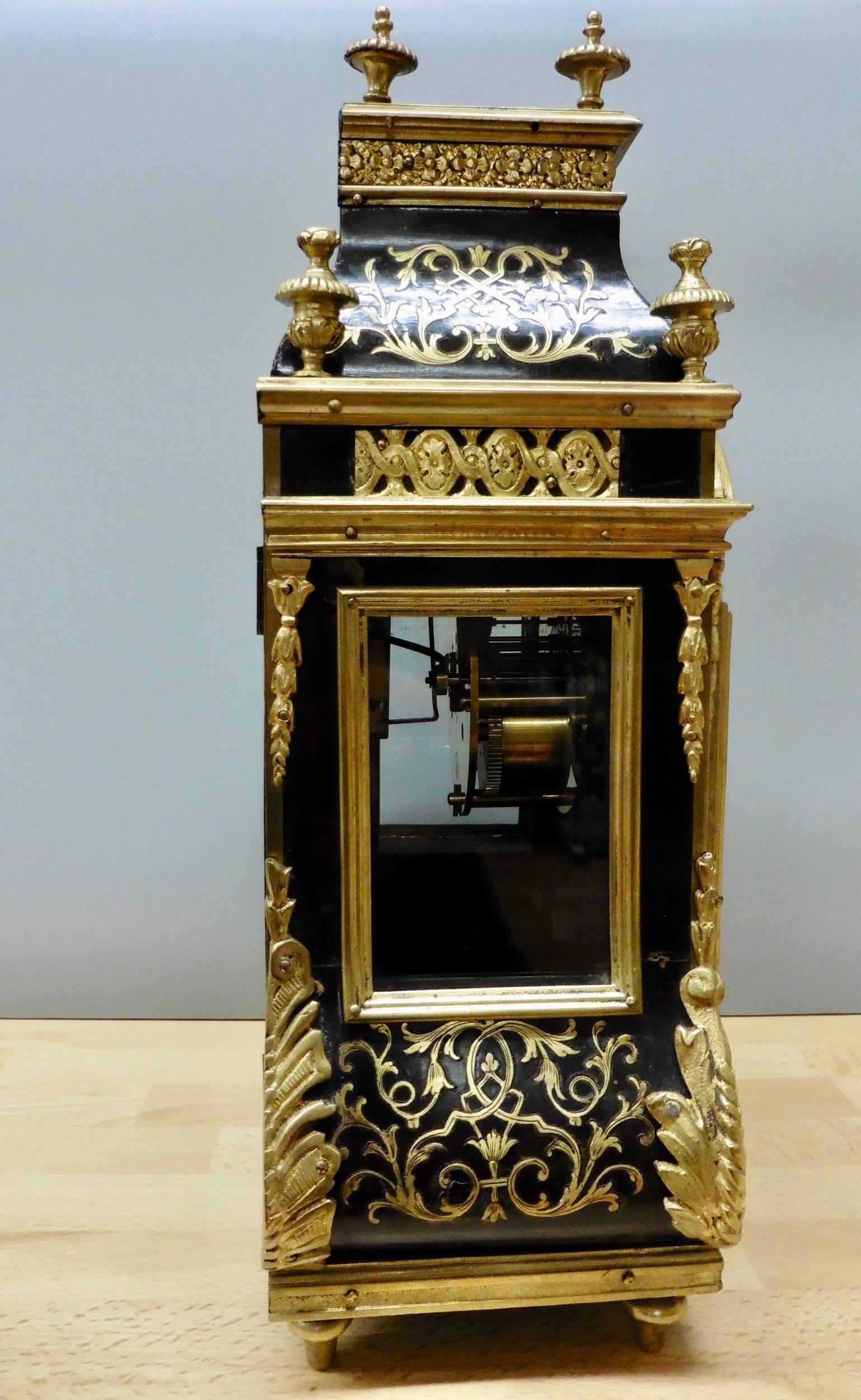 French Boulle Tortoiseshell mantel clock in a beautifully decorated ‘Bombe’ shaped case with ormolu mounts surmounted by eight gilded finials.

Brass bound side viewing windows, foliate cast mounts, the base edged with a gilt band divided by