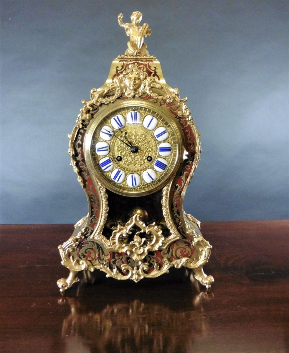French Tortoiseshell Boulle Clock c.1860

Waisted case veneered with red tortoiseshell with finely figured brass and ormolu mounts, surmounted with an ormolu cherub. Glazed viewing panel to the front of the case with front ormolu mount. The back