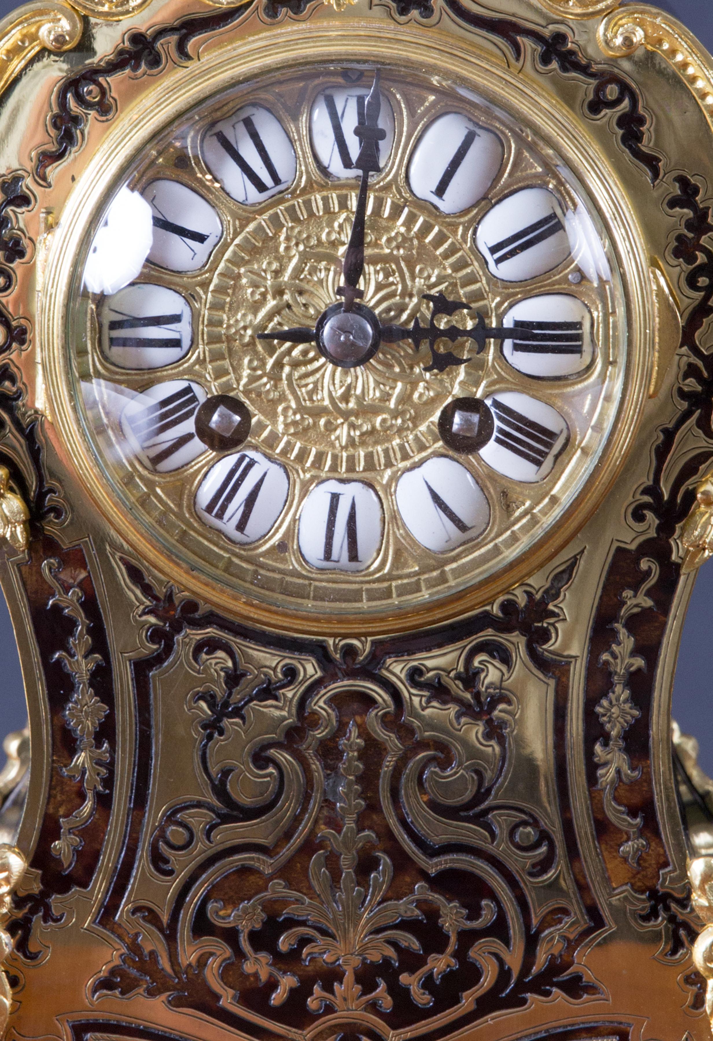 French Tortoiseshell Boulle clock with ormolu mounts surmounted by a brass finial.

Gilded dial with individual enamel segmented Roman numerals.

Eight day movement striking the hours and halves on a coiled gong, rear door with silk lined sound