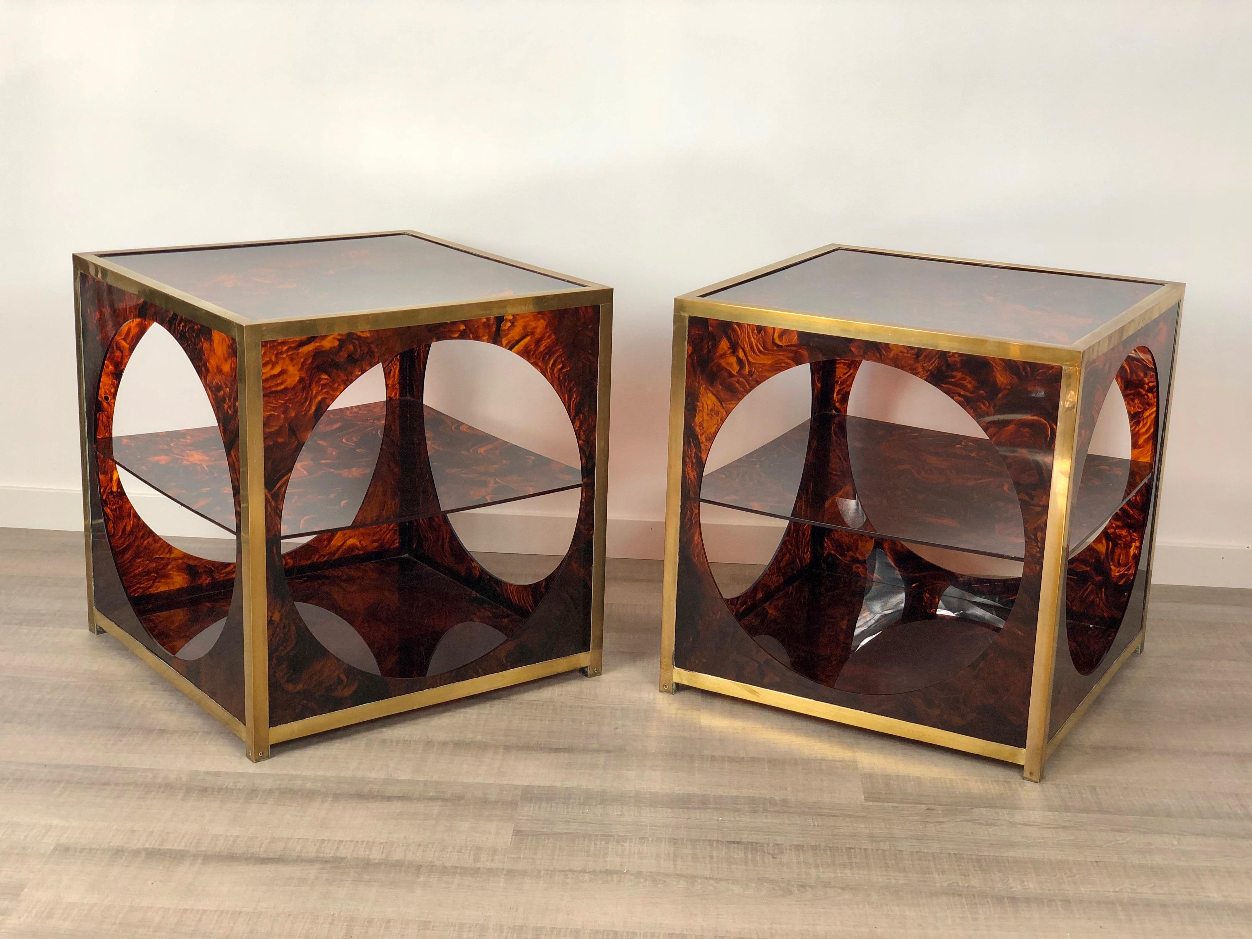 Pair of elegant side/coffee tables in faux tortoiseshell Lucite and brass details. They feature a unique geometrical design that remembers 1970s Christian Dior style: an open cube with circular windows inside which a Lucite shelf is placed.
  