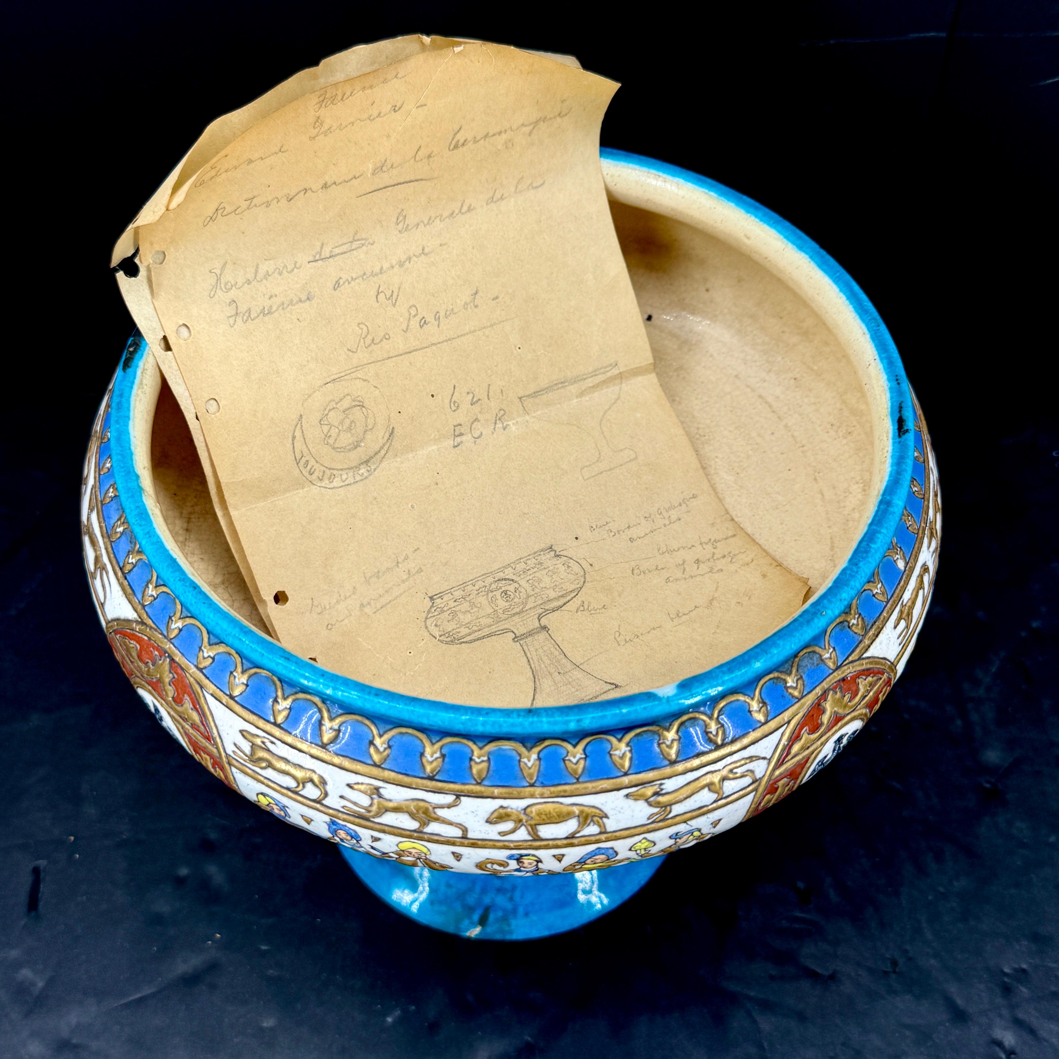 This glazed bowl is a 19th Century reproduction of a 16th Century Persian Enameled Glass Bowl. The vibrant colors on this bowl feature people as well as animals and a crest with a Phoenix in the center. We see this impressive bowl or coupe on a
