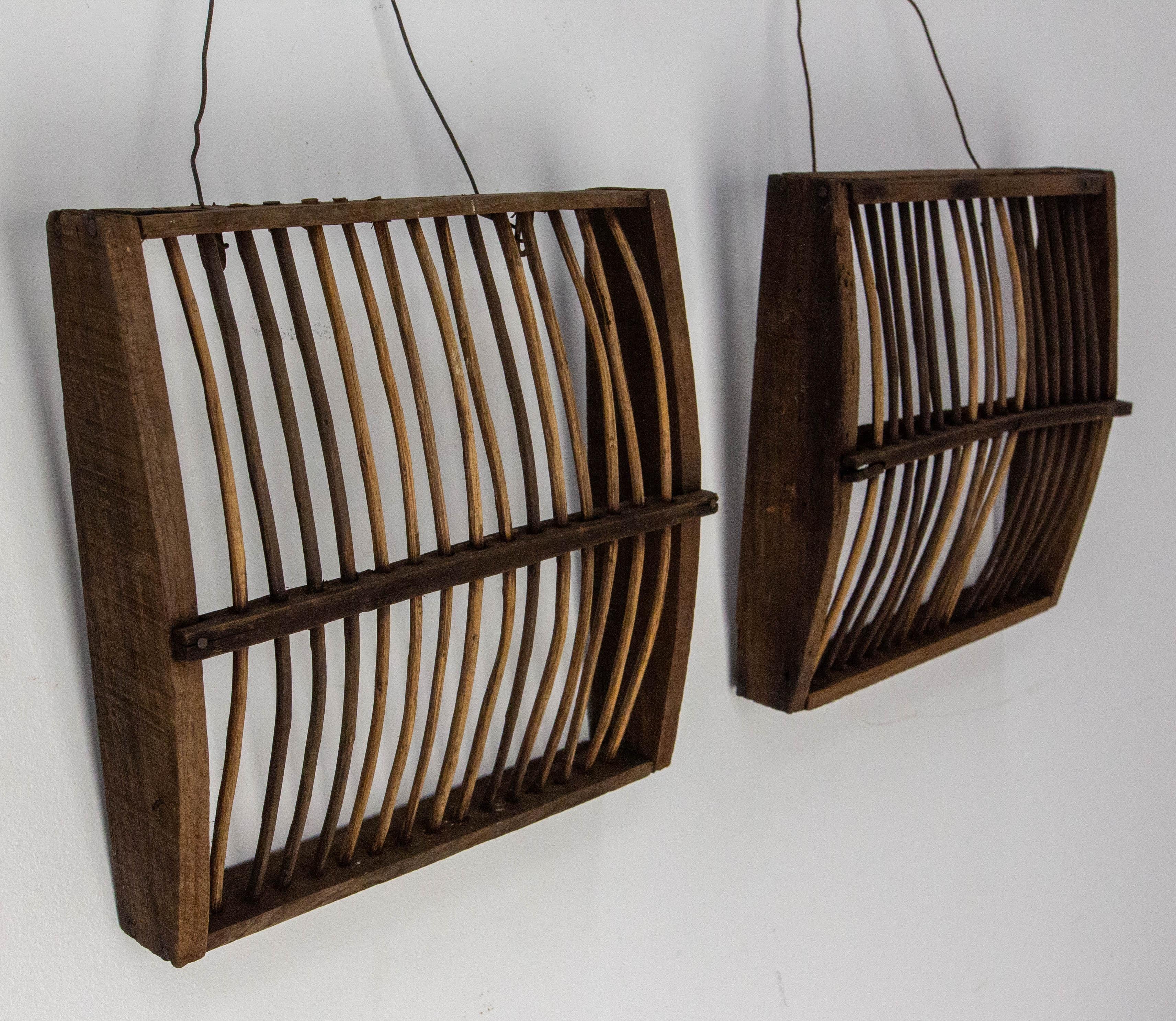 Questi due piccoli oggetti in legno e rattan venivano tradizionalmente utilizzati come trappole per piccoli uccelli nelle campagne del sud-ovest della Francia.
Oggi sono perfetti per una decorazione murale naturale o per creare una coppia di