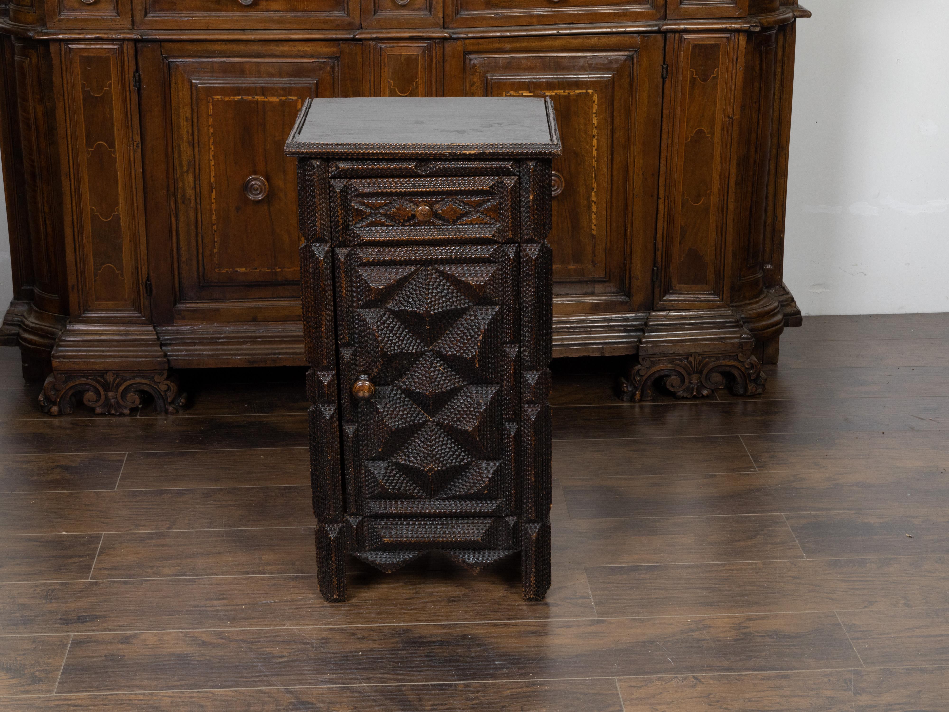An unusual French Tramp Art small cabinet from the early 20th century, with raised geometric motifs. Created in France during the early years of the 20th century, this small cabinet features a rectangular top sitting above a drawer fitted with a