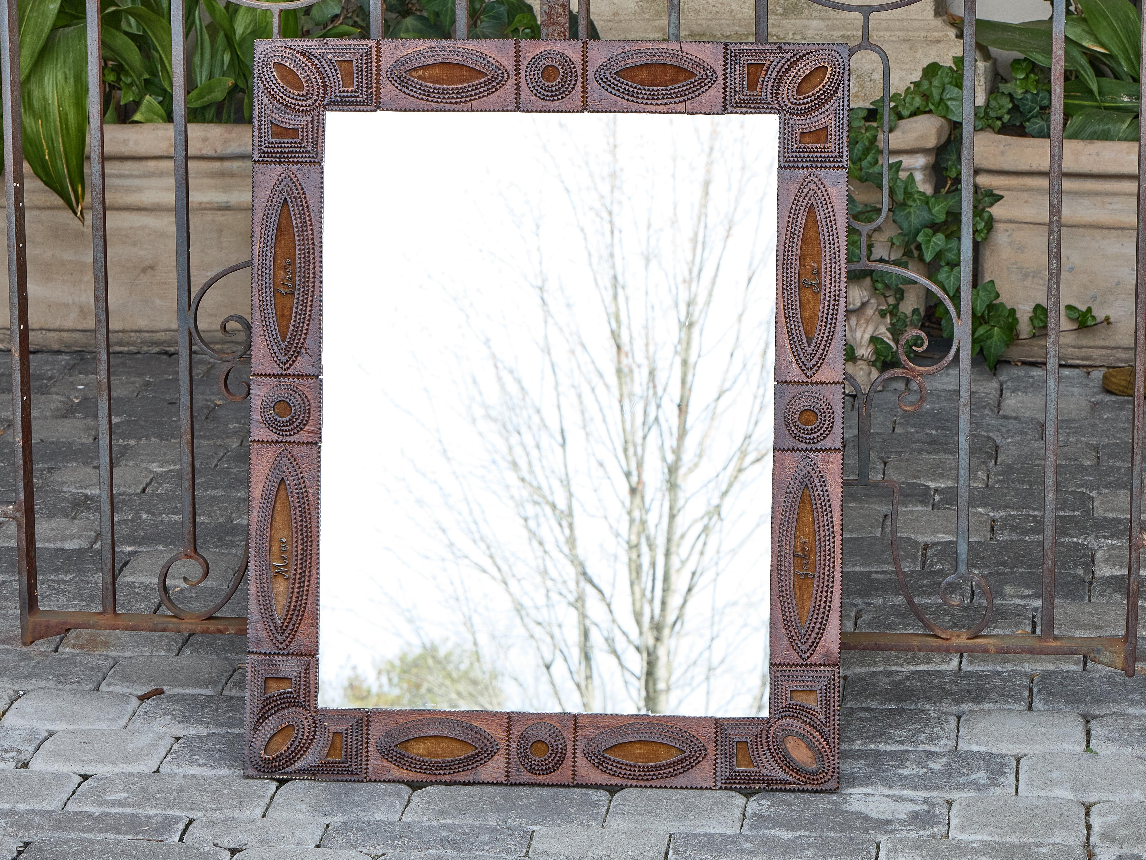 Ce miroir du Tramp Art français du début du 20e siècle capture l'ingéniosité et la géométrie en couches qui définissent la tradition. Entièrement sculpté à la main, le cadre présente un arrangement complexe de bois de boîte à cigares entaillé et