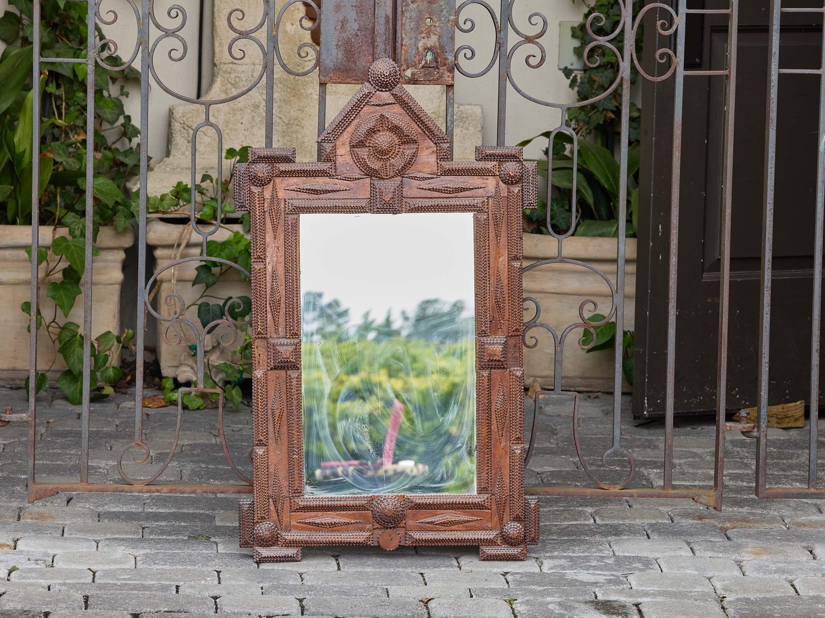 Un miroir de Diptych Fine Arts français datant d'environ 1900, construit avec les détails denses et rythmés de la sculpture sur bois qui définissent la tradition. Le cadre est construit en plusieurs niveaux, chacun entaillé et facetté à la main,