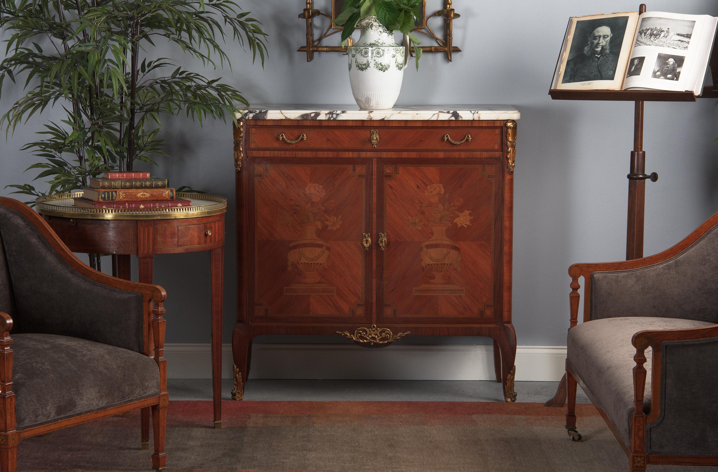 An ornate Louis XV and Louis XVI Transition style sideboard with elaborate marquetry and marble top, French, circa 1900. Cherrywood veneer along with other veneers of exotic and fruit woods, brass hardware and a thick Calcatta Viola marble top. Both