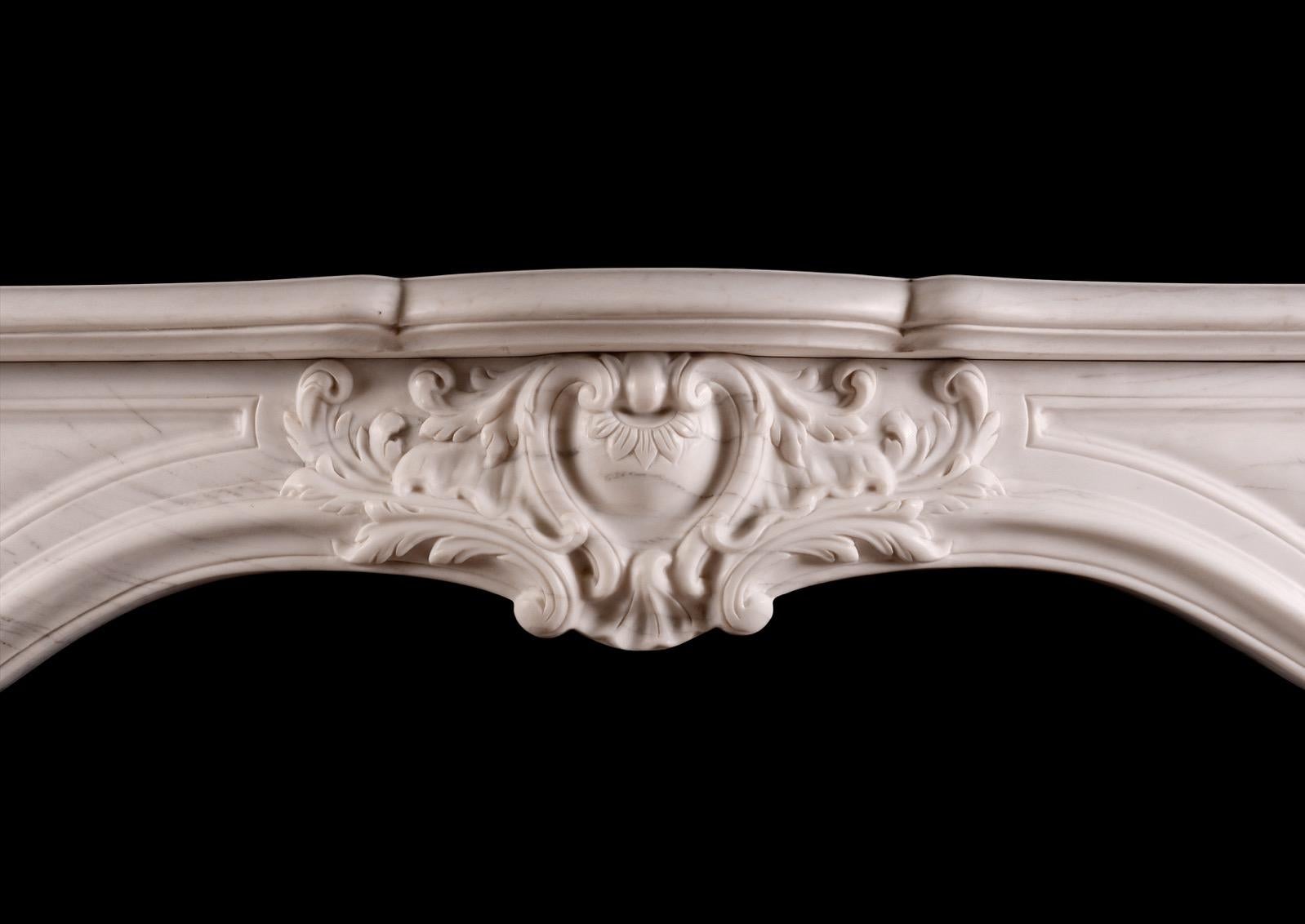 A good quality copy of an 18th century French transitional Louis XIV/XV marble fireplace. The shaped frieze with cartouche centre with scrolls and leaves, juxtaposed by moulded panels. The shaped jambs with stiff acanthus leaf and scroll bases,