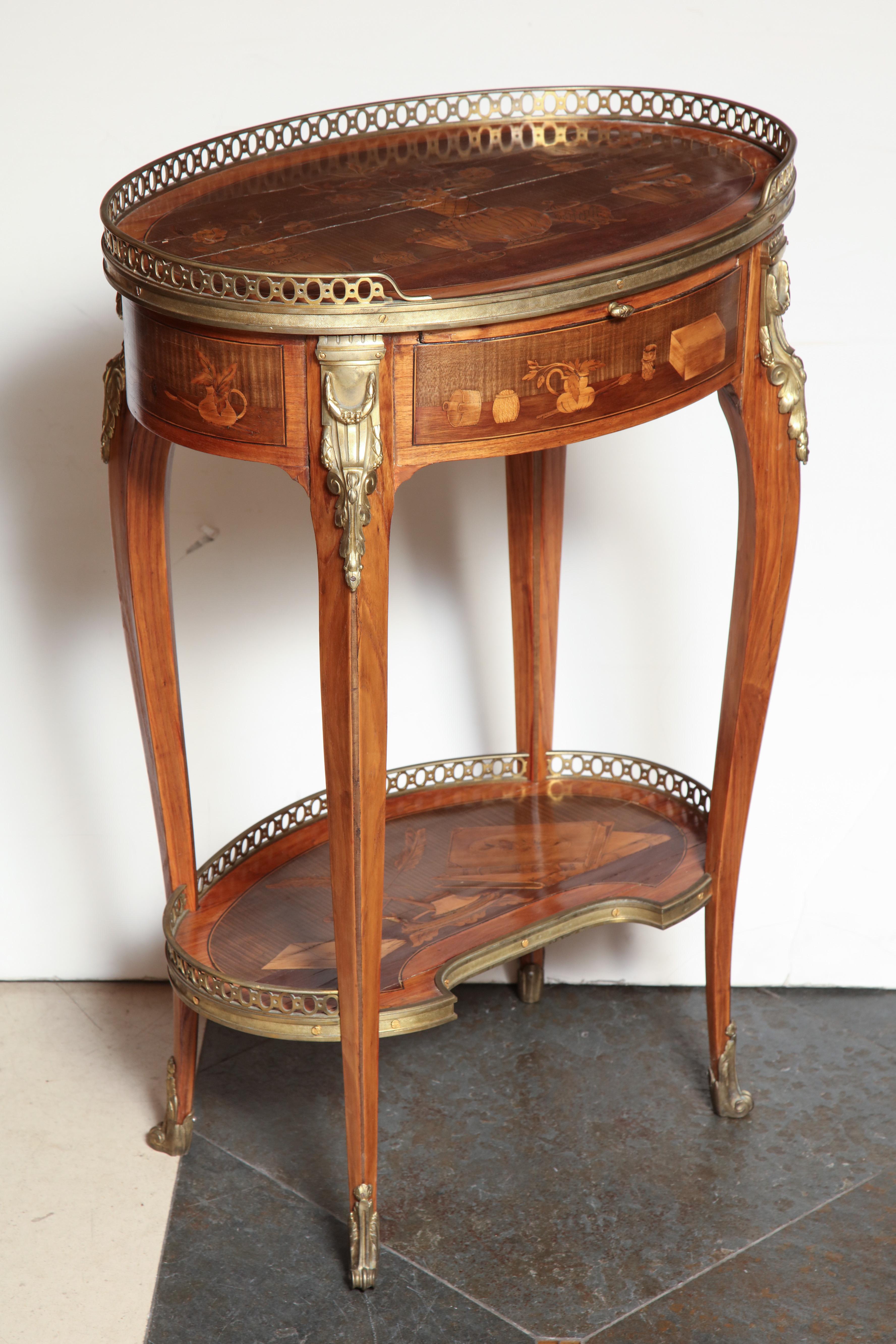 A fine French Louis XV-XVI transitional oval side table with elaborate marquetry decorative scenes, in the manner of Charles Topino. With pierced bronze galleries, mounts, and sabots.