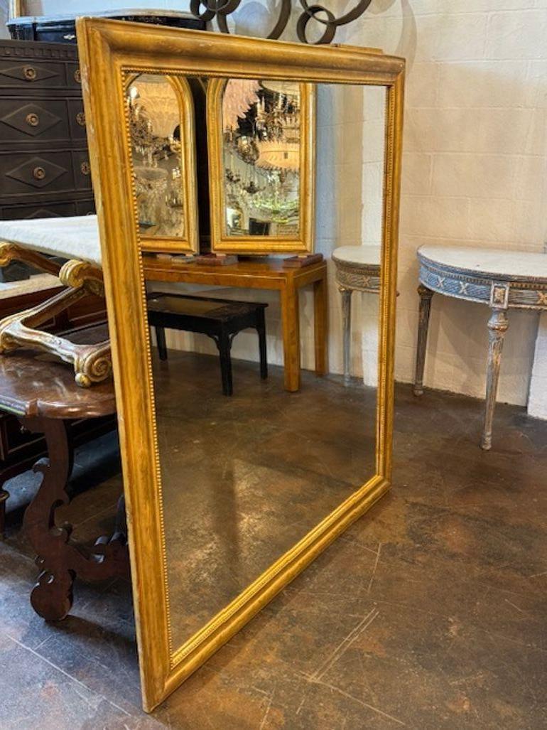 19th century French transitional gilt-wood rectangle mirror with floral pattern frame. You're exploring a mirror that bridges Rococo exuberance and Neoclassical restraint—19th-century French transitional giltwood rectangular mirrors with floral