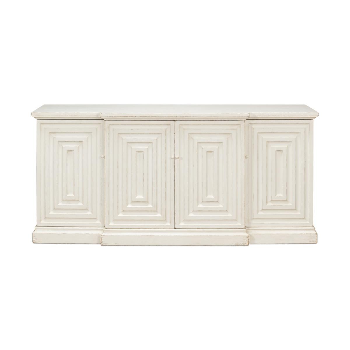 French transitional painted sideboard, in an antiqued white distressed painted finish, the breakfront sideboard has geometrical relief panels to the four doors, with interior shelves and raised on a plinth base.

Dimensions: 75