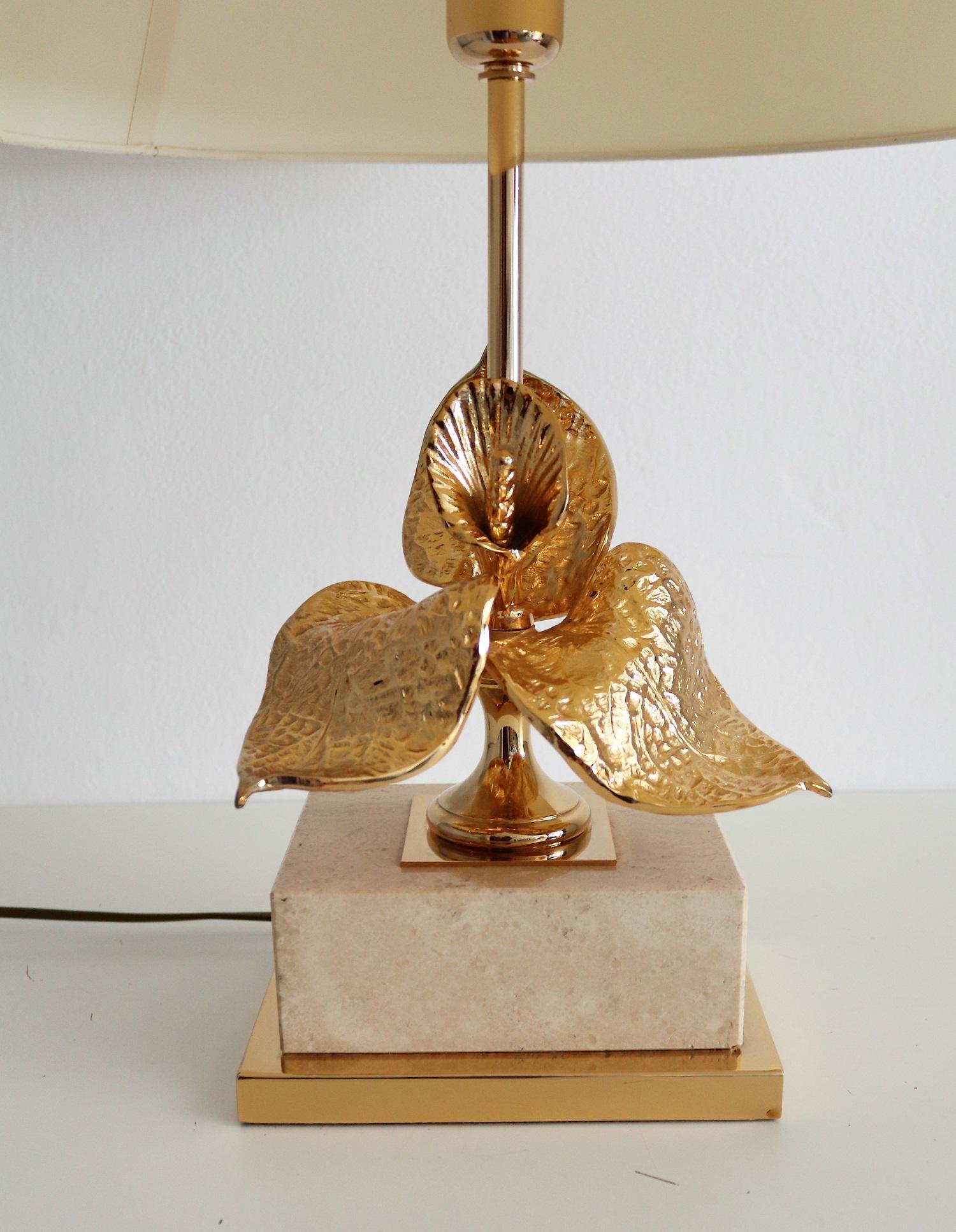 Beautiful table lamp with heavy travertine base and gold plated brass flower.
Made in France attributed to Maison Charles during the 1970s.
The lamp is in nearly excellent original condition with smallest signs of wear and fits still the original