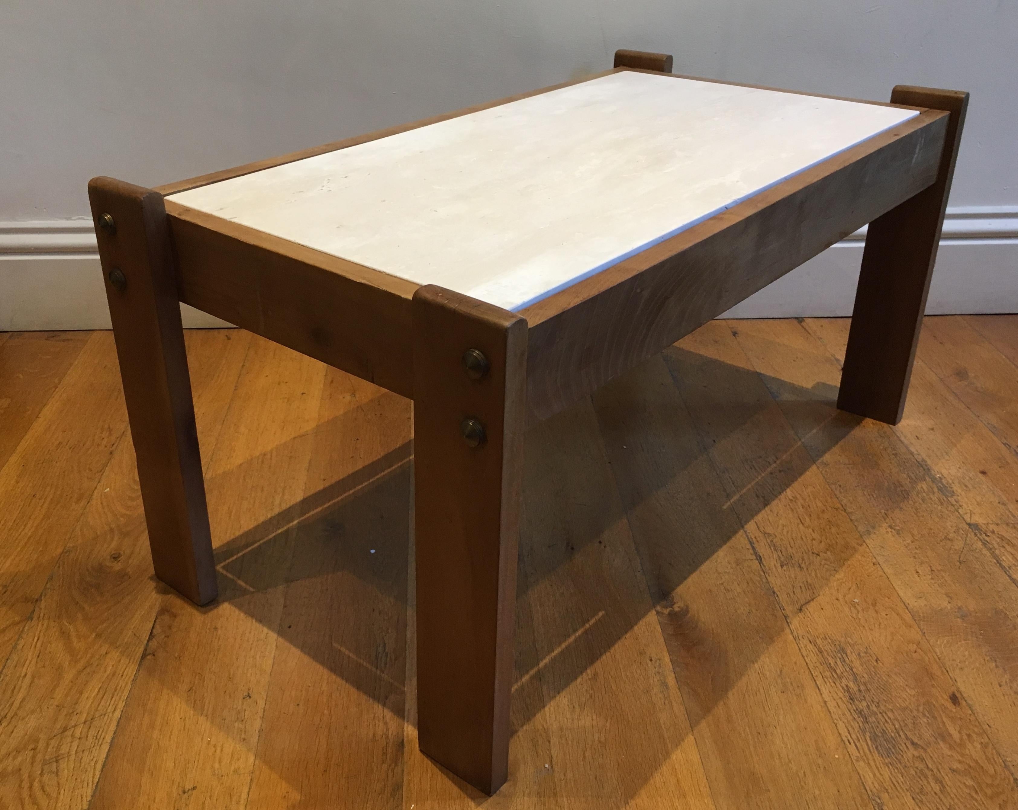 An elegant cherrywood and unfilled travertine top (replaced) coffee/centre table with bronze details. An unrestrained design, in the manner of Jacques Adnet.
