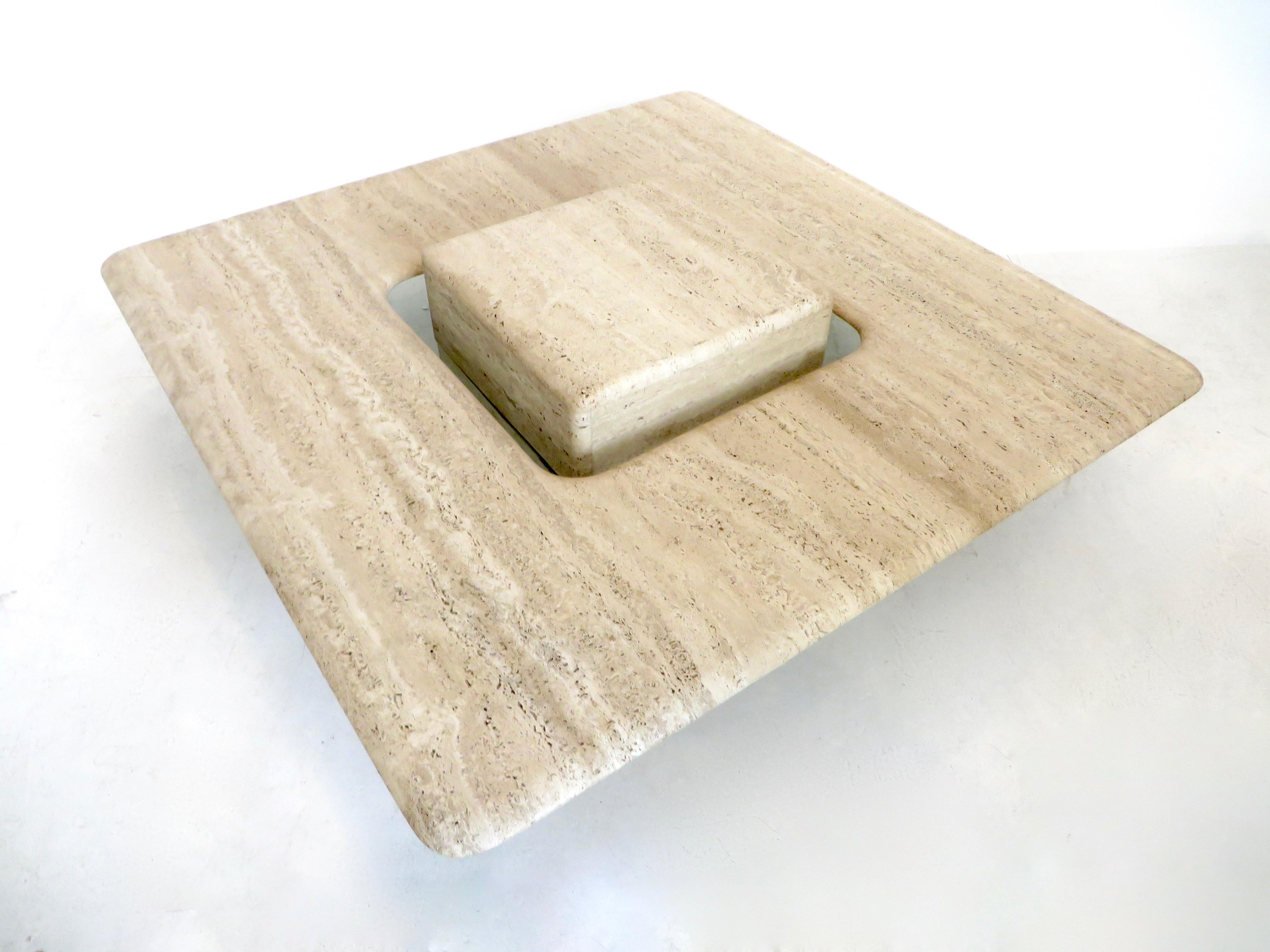 A Minimalist French, circa 1970 travertine marble coffee table.
Italian honed matte and natural travertine marble low square coffee table with a floating cube in the center that is elevated by a piece of glass that is semi noticeable. The cube then