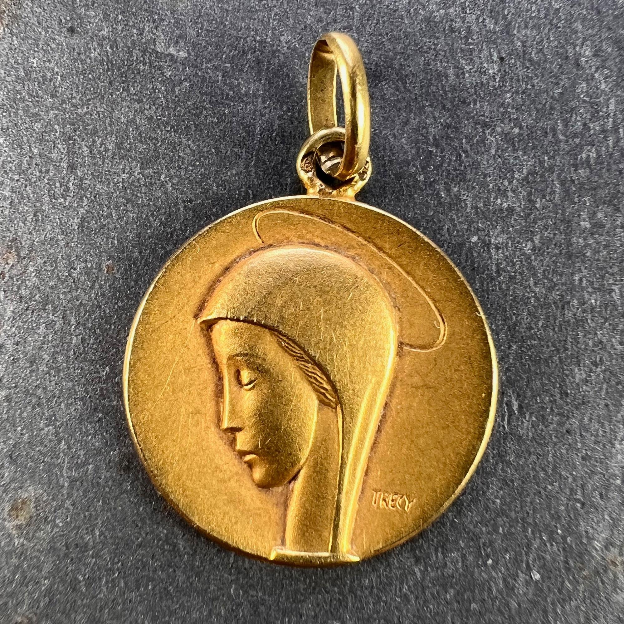 Ein französischer Anhänger aus 18 Karat (18K) Gelbgold in Form einer Medaille mit der Darstellung der Jungfrau Maria, signiert von Trecy. Gestempelt mit der Adlerkopfmarke für 18 Karat Gold und französische Herstellung sowie einer unbekannten