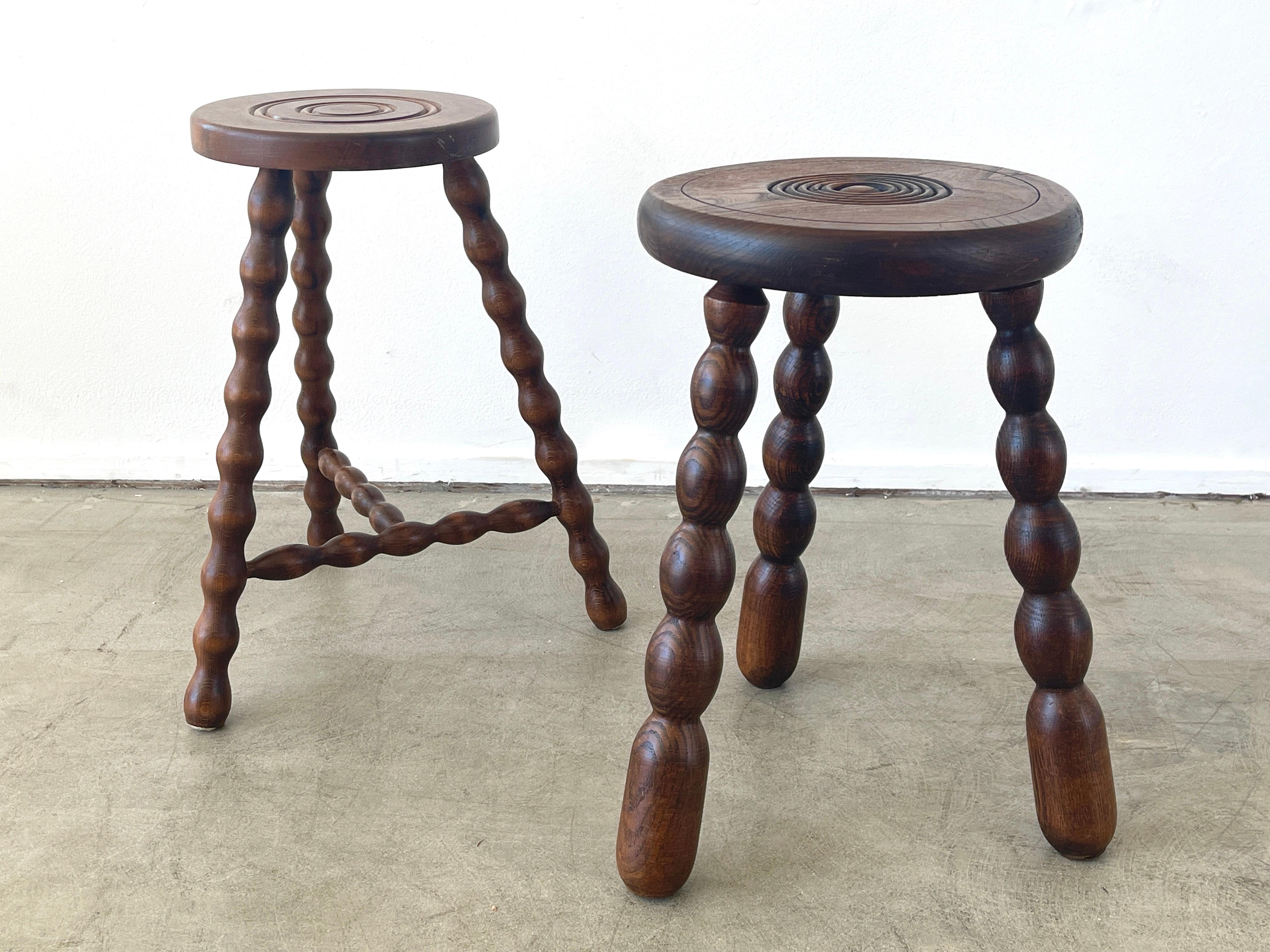 French circular wood stool with unique wavy carved legs.
Circular ring carvings on seat.
Great patina.

Stool 1 - 18.25 height x 11.25 diameter
Stool 2 - 18.75 height x 9.75 diameter.