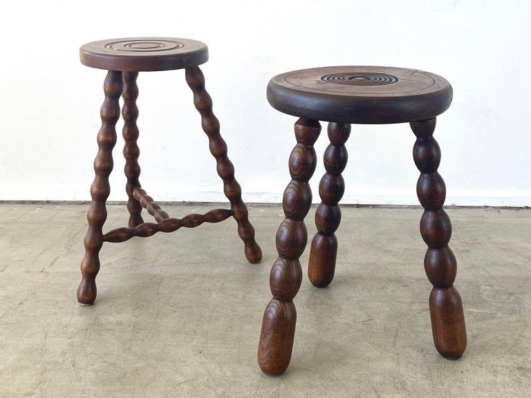 French circular wood stool with unique wavy carved legs.
Circular ring carvings on seat.
Great patina.

Stool 1 - 18.25 height x 11.25 diameter
Stool 2 - 18.75 height x 9.75 diameter.