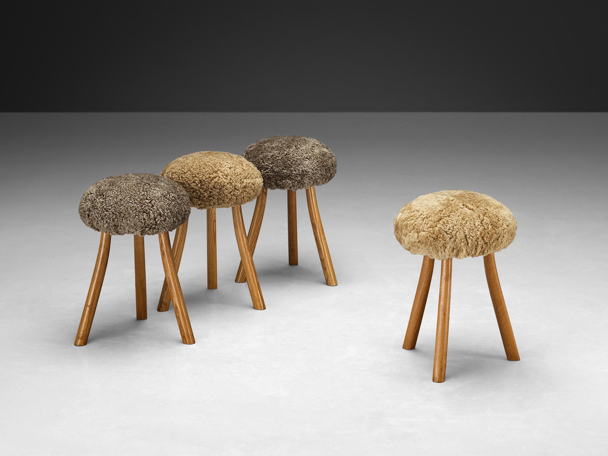 Tripod stools or side tables, solid elm, shearling wool, France, 1970s

Beautiful crafted elm stools originating from France. The seats are reupholstered in a soft shearling woolen fabric in the colors beige and grey. The feet are unevenly carved in