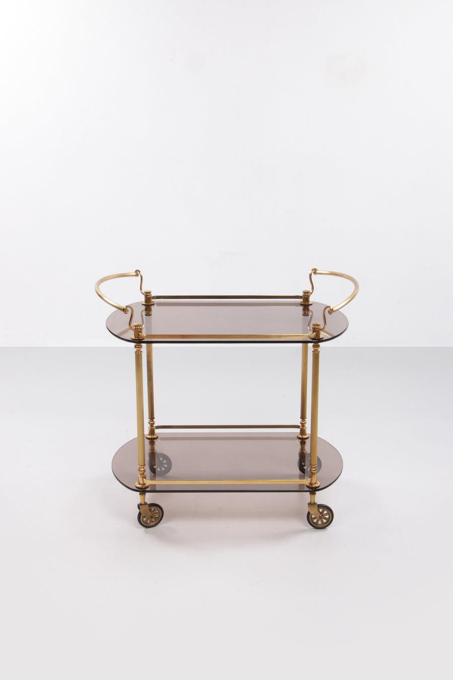 French Trolly Hollywood Regency Style with Smoked Glass 1960s.

You'll make a splash with this stylish French drinks trolley. 

Typical design for the 60s, combines perfectly in both a modern and vintage interior.

Country of origin: France

The
