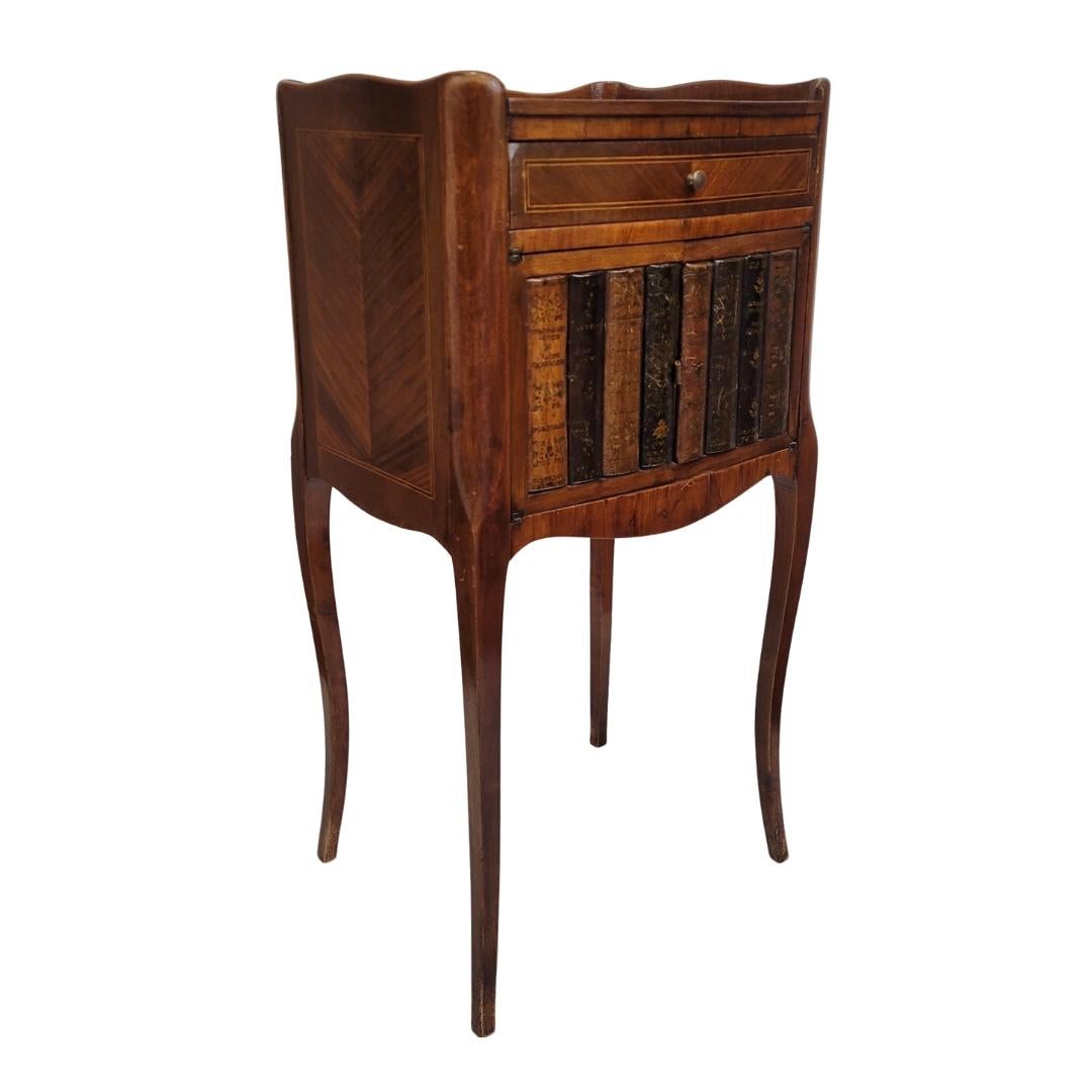 Un delizioso tavolino in legno con intarsio e decorazione a trompe-l'oeil sul cassetto inferiore, in stile Napoleone III.

Il piano del tavolo presenta un'eccellente figura a intarsio con motivi floreali, delimitata su tutti i lati tranne che sul
