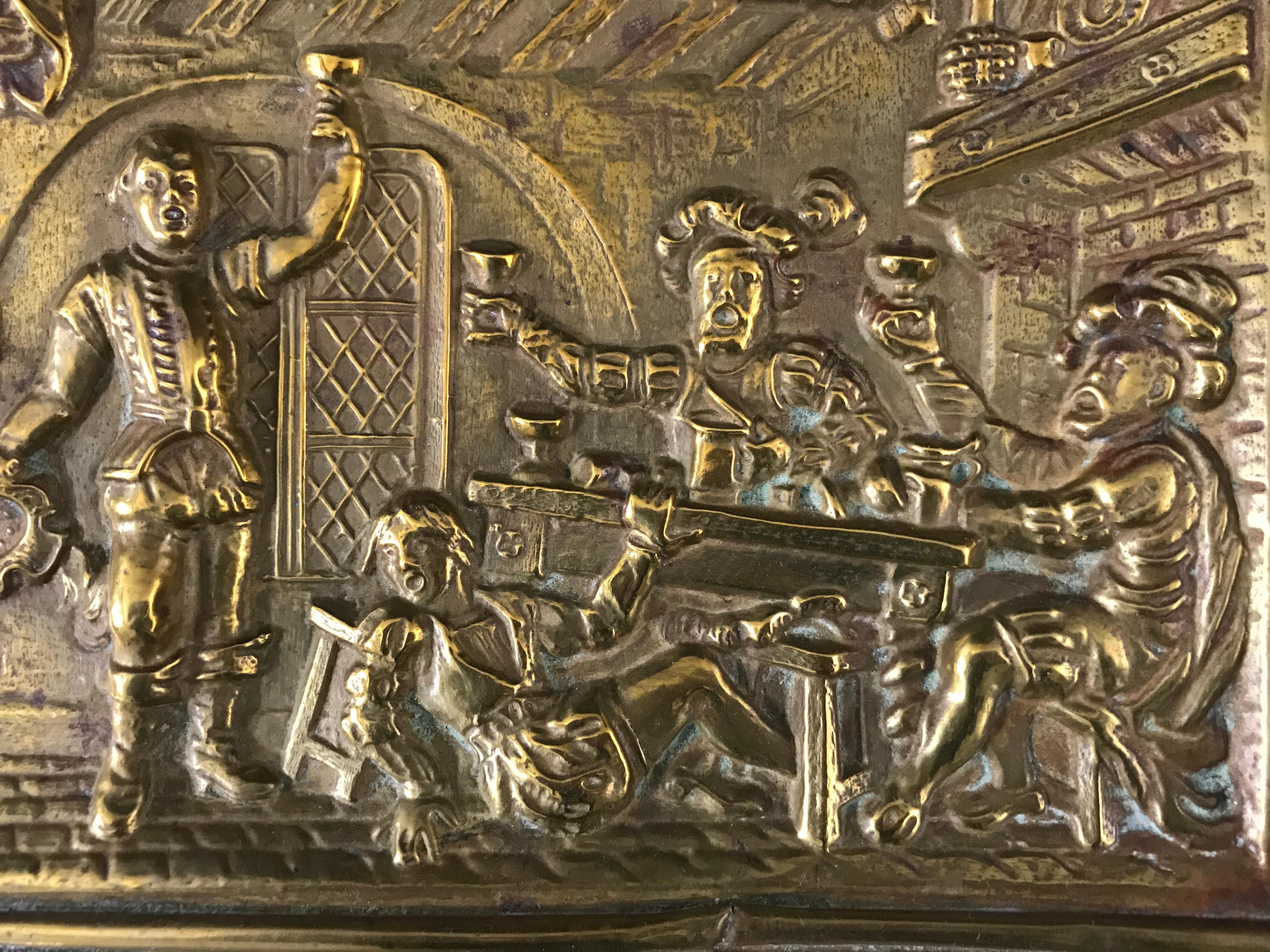 Pretty embossed copper plate representing a tavern scene in the style of the 16th century. In a renaissance interior four men are drinking, three of them lift their cups, the fourth, visibly drunk, has fallen from his seat. A maid enters the room