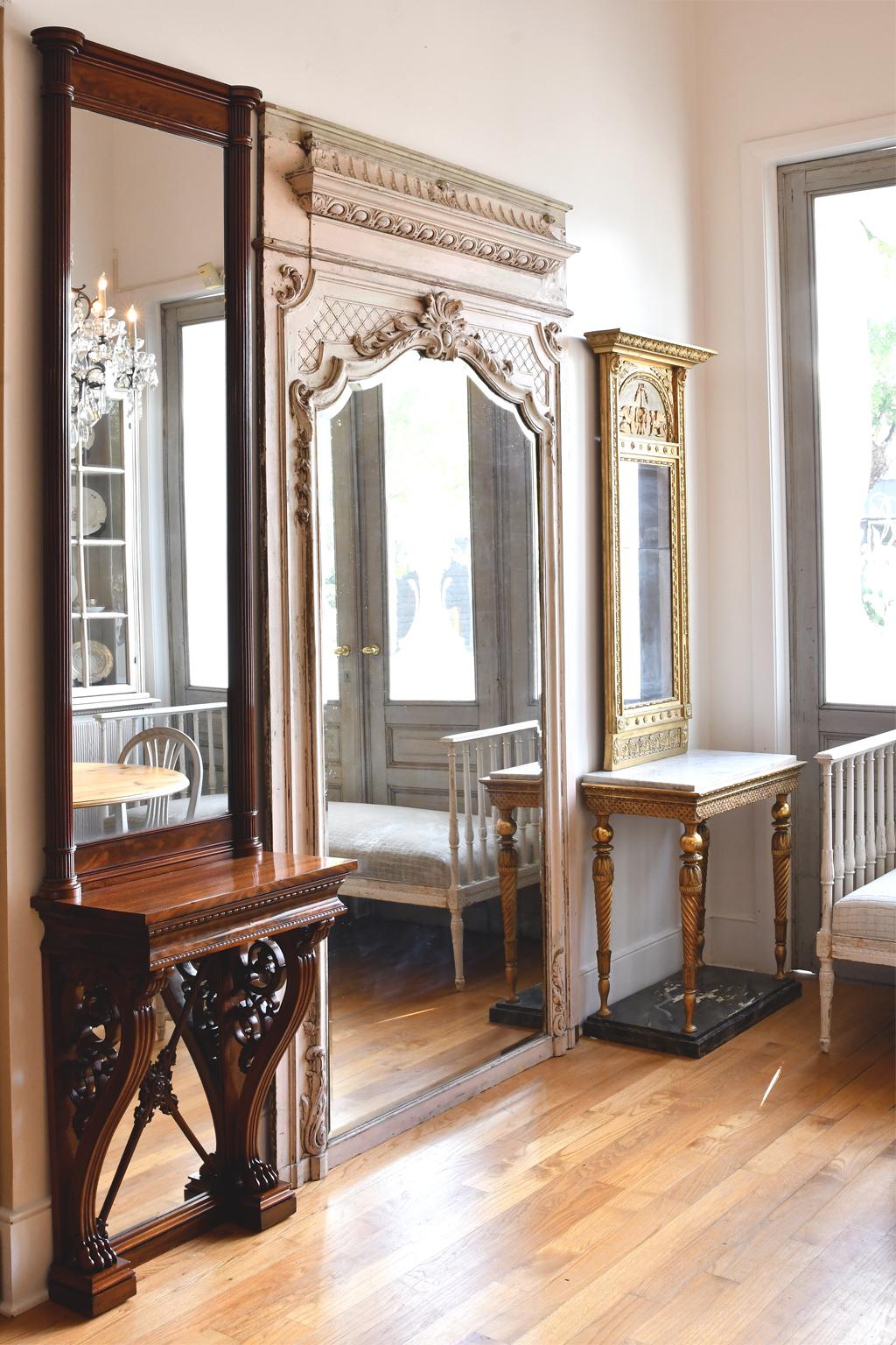 A very lovely French trumeau mirror in carved and painted wood with white distressed finish. France, circa 1880. Originally part of a paneled room, this Louis XVI style trumeau mirror has an imposing presence with a height of 104