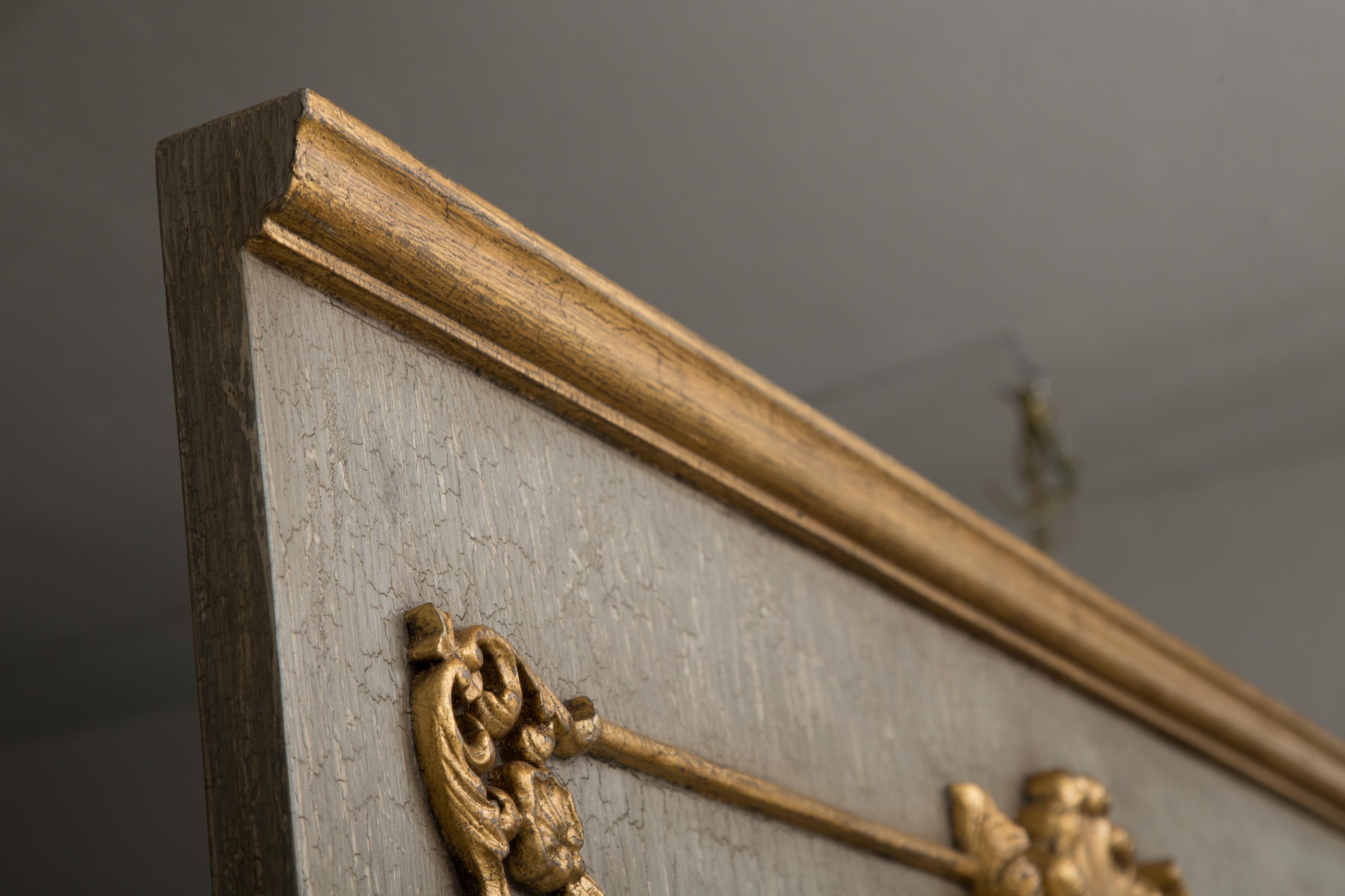 This is a 20th century period appropriate copy of an 18th century French Trumeau mirror. Highlighted in gilt with a grey crackled finish that surrounds a beveled arched mirror.