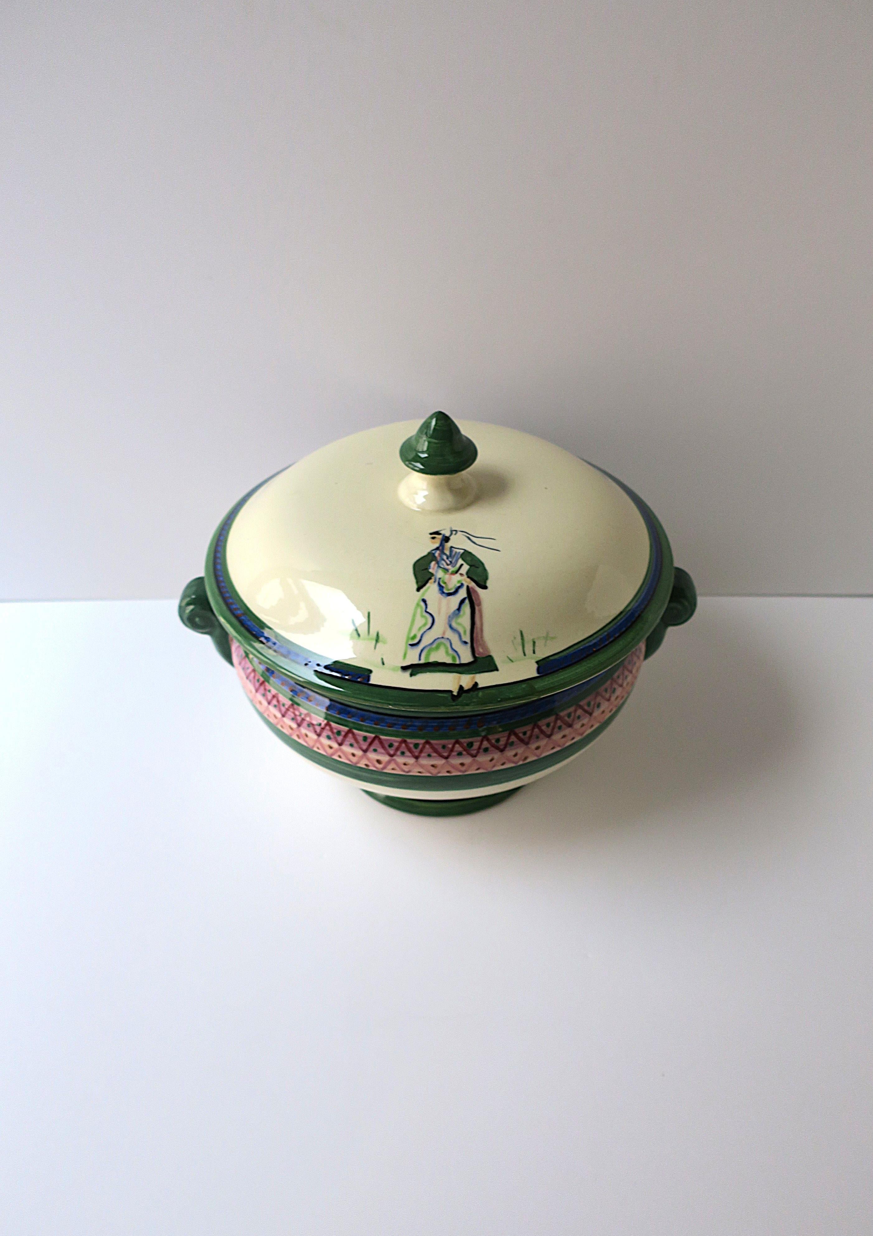 Une belle et chic soupière en faïence française entièrement peinte �à la main de Henroit, vers le début ou le milieu du 20e siècle, France. La soupière représente une femme chic dans une belle robe sur le couvercle. Cette pièce a été fabriquée en