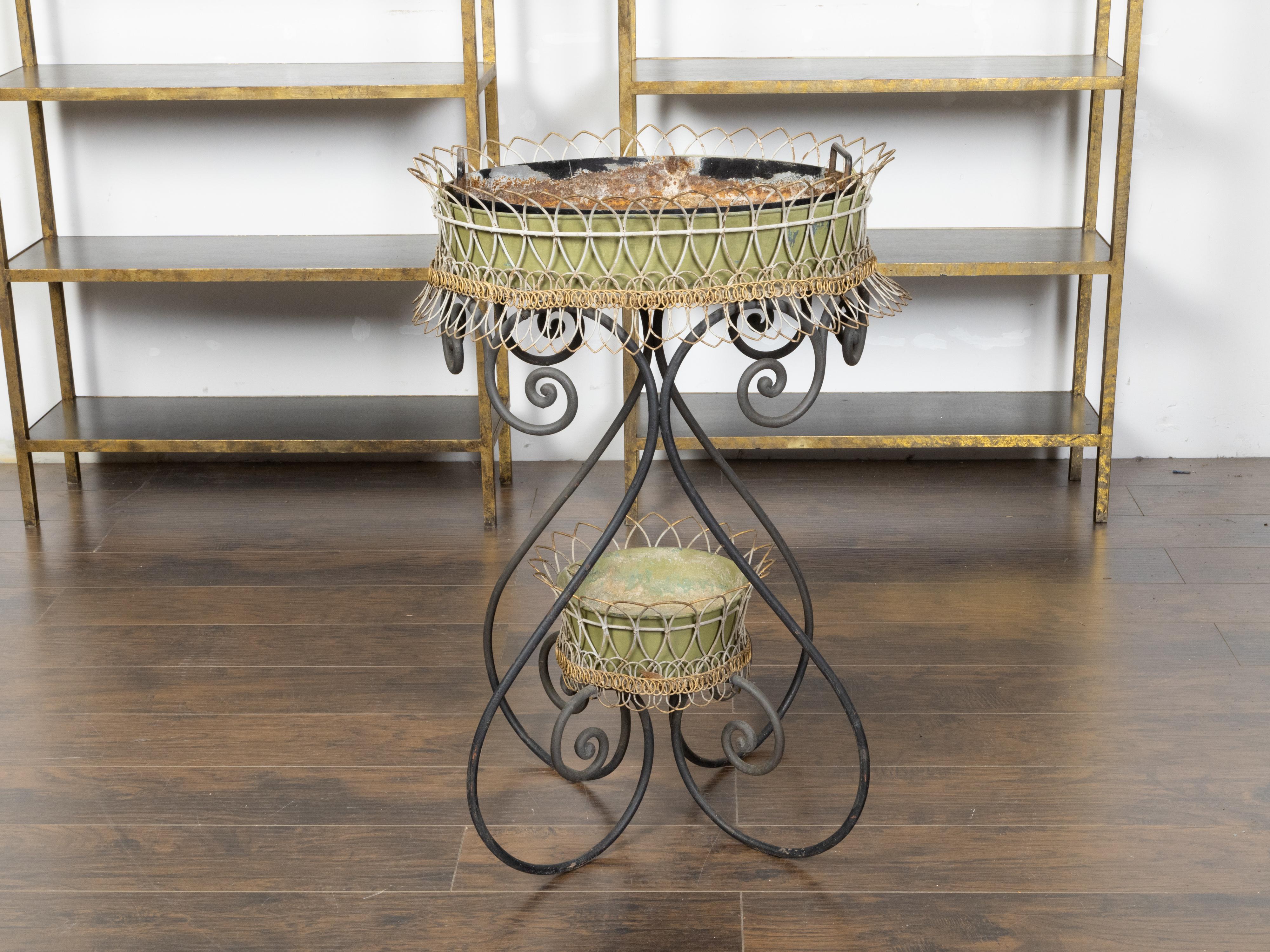 Una jardinière francese a due livelli di forma ovale dei primi del Novecento, con metallo verniciato in verde e bianco, accenti a volute e aspetto rovinato dalle intemperie. Creata in Francia durante la Fine del Secolo, nei primi anni del XX secolo,