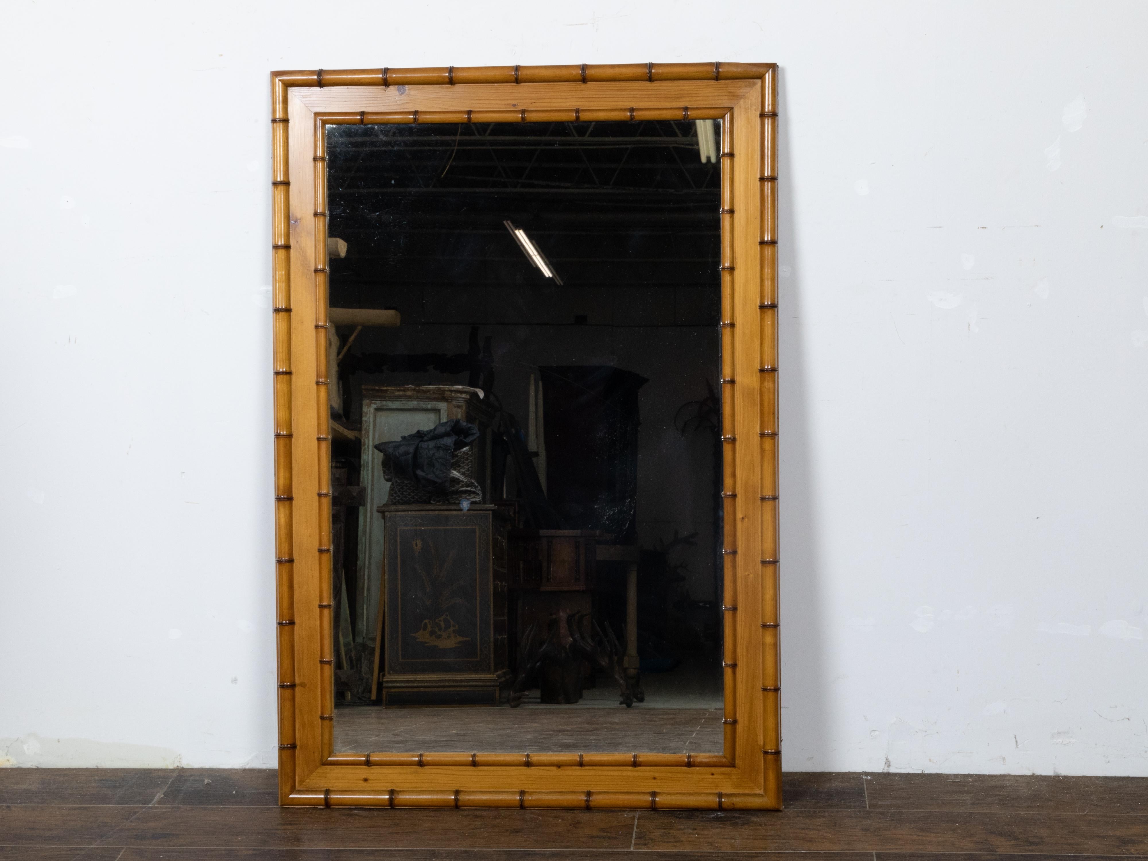 A French Turn of the Century faux bamboo brown frame mirror from circa 1900. Step into the charm of the French Turn of the Century with this elegant faux bamboo brown frame mirror, circa 1900, a piece that beautifully marries the allure of nature