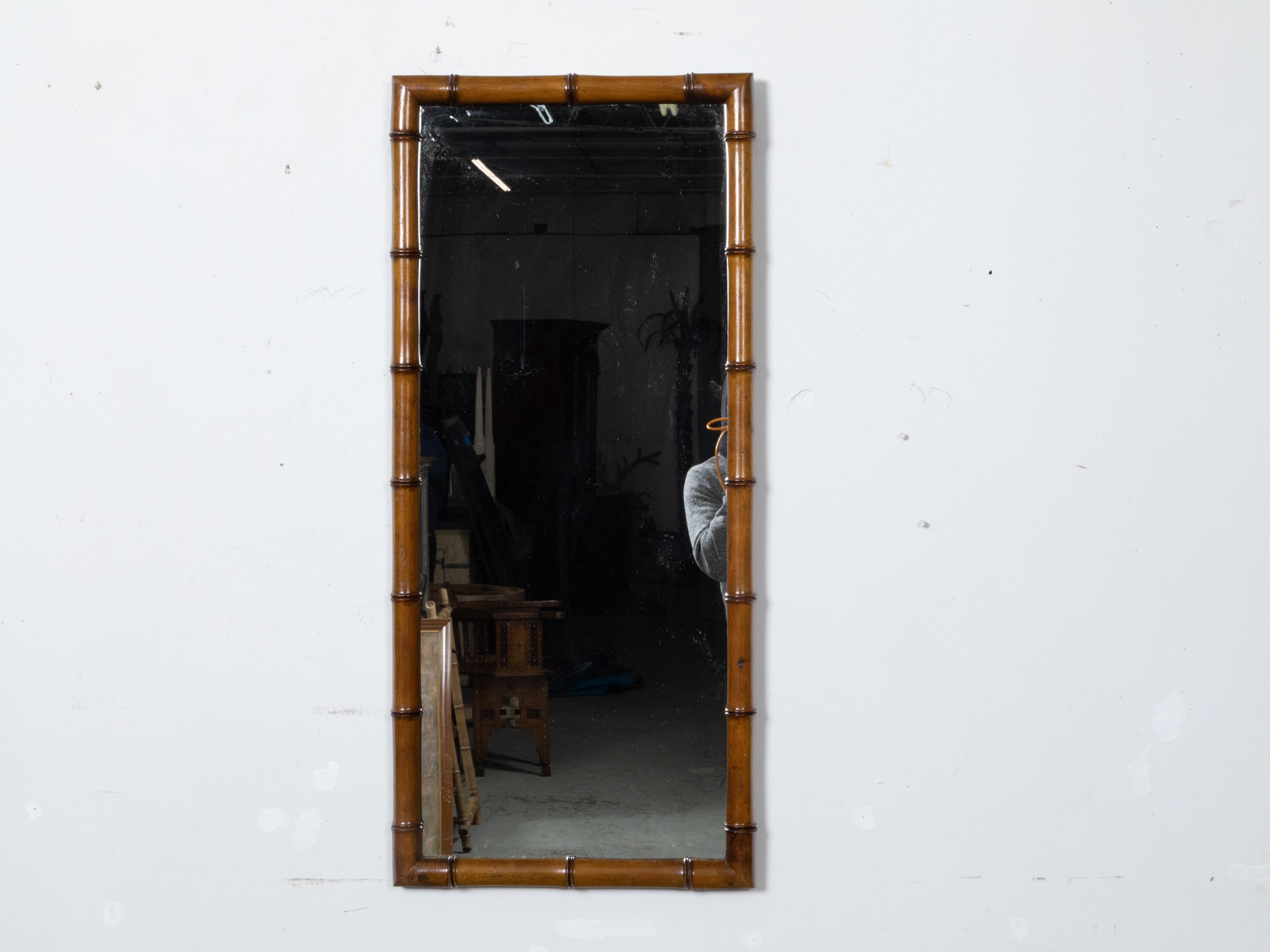 This French faux bamboo mirror from the Turn of the Century, circa 1900, features simple lines, a clear mirror plate, and a warm brown patina. The mirror embodies the understated sophistication characteristic of French design during this period,