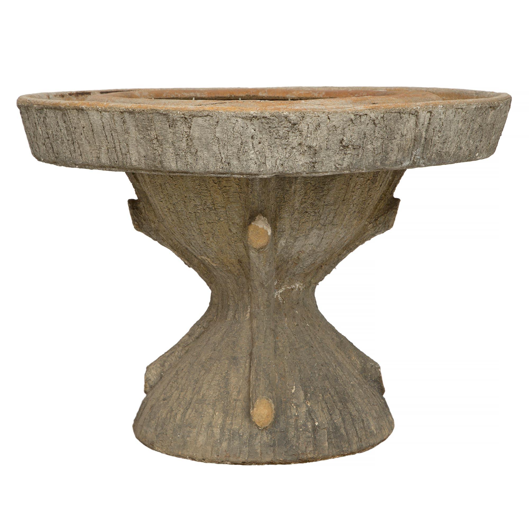 A beautiful French turn of the century Faux Bois fountain planter. This wonderful and unique planter is raised by a most decorative Faux Bois base with charming knots to mimic a tree trunk. Above is a circular planter which extends along the outer