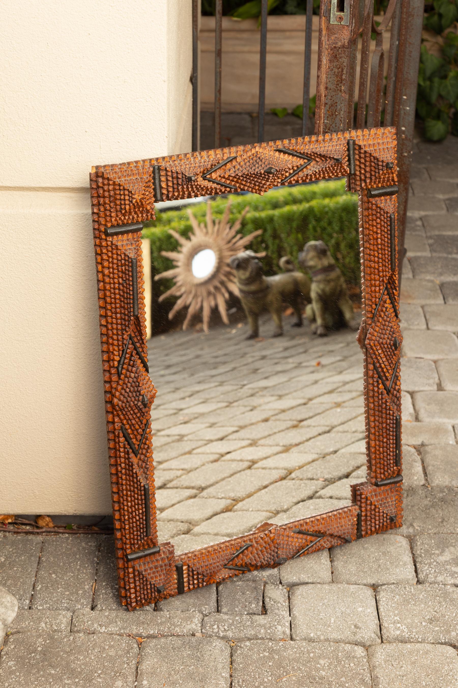 A French Tramp Art hand carved wooden mirror from the early 20th century with raised diamond motifs and ebonized accents. Born in France during the turn of the century, this French mirror was hand carved in the manner typical of the Tramp Art style.