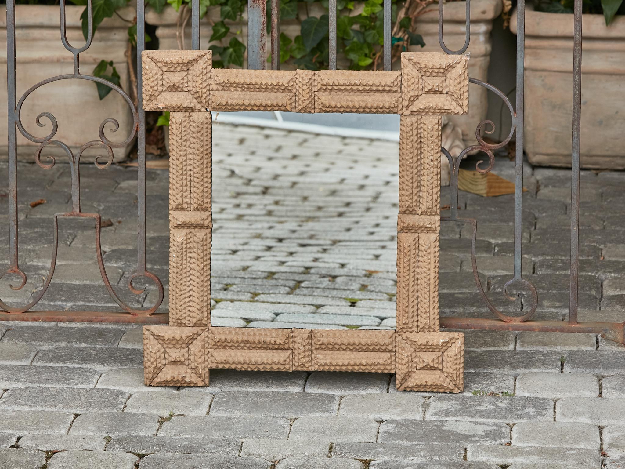 A French Turn of the Century Tramp Art hand-carved wooden mirror from circa 1900 with square protruding corners. Step back in time and embrace the rustic charm of this exquisite French Turn of the Century Tramp Art hand-carved wooden mirror from