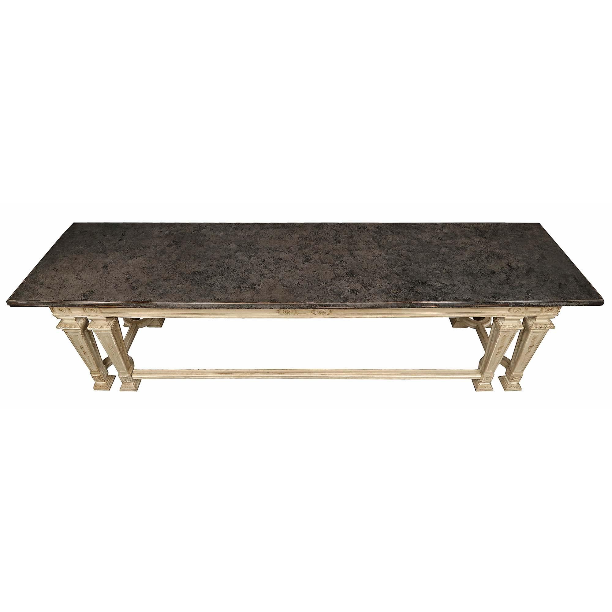 A very attractive French turn of the century Louis XIV style the patinated center or library table. The table is raised by eight handsome square tapered legs with richly carved feet, block cabochons, and arrows on a recessed panel, connected by a