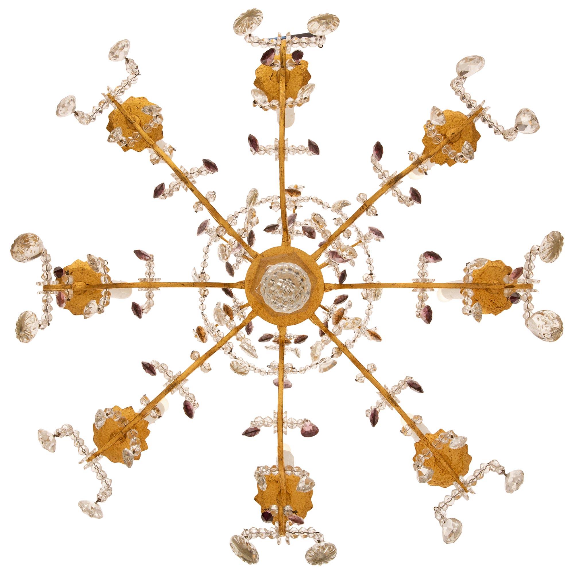 A lovely French turn of the century Louis XV st. gilt metal and crystal chandelier. The eight arm chandelier is centered by a fine bottom facetted cut crystal ball below a lovely curved crystal support from where the arms branch out. Each of the