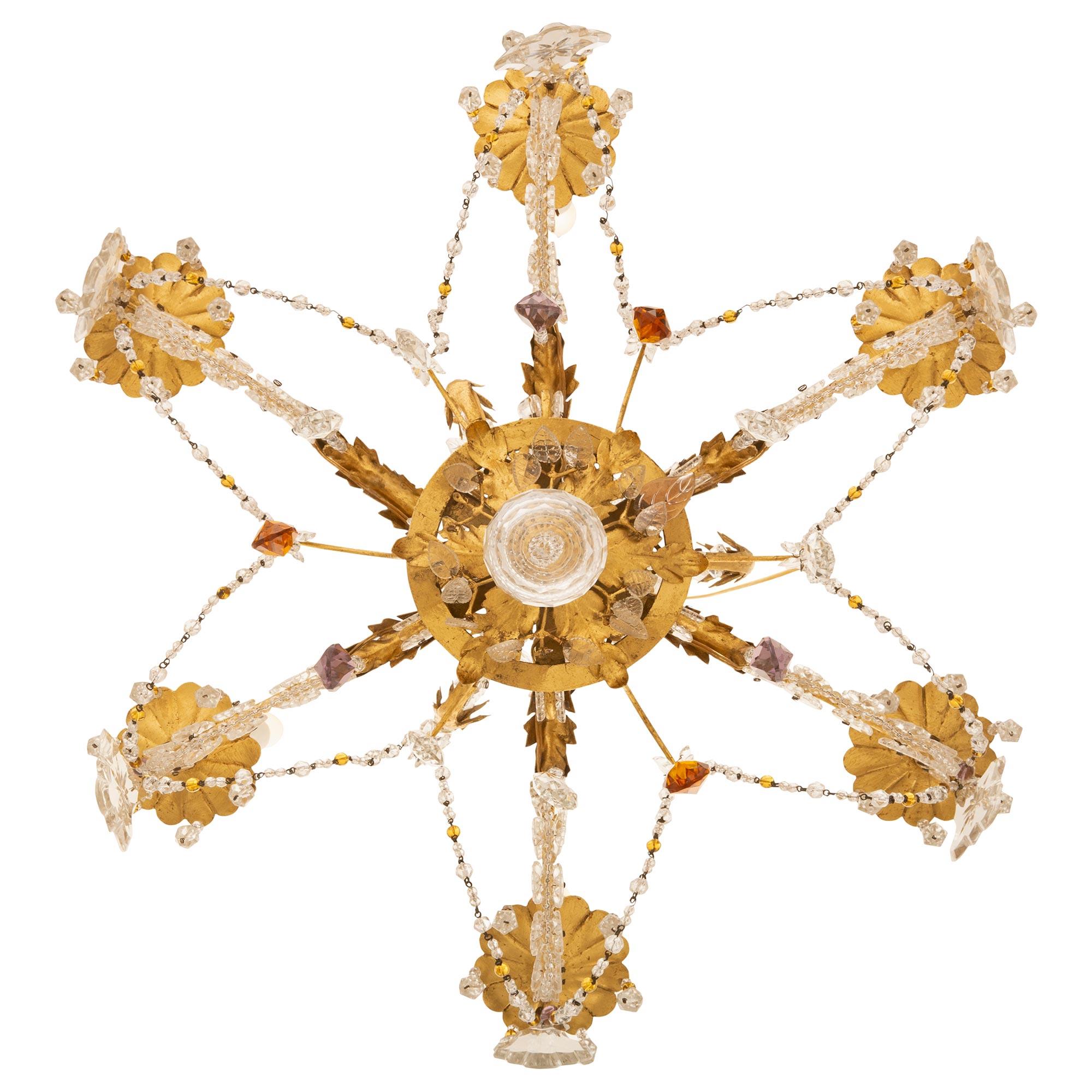 A beautiful French turn of the century Louis XV st. Gilt Metal and Baccarat crystal chandelier, attributed to Maison Bagues. The six arm chandelier is centered by a most decorative and lovely Gilt Metal foliate reserve and a superb array of teardrop