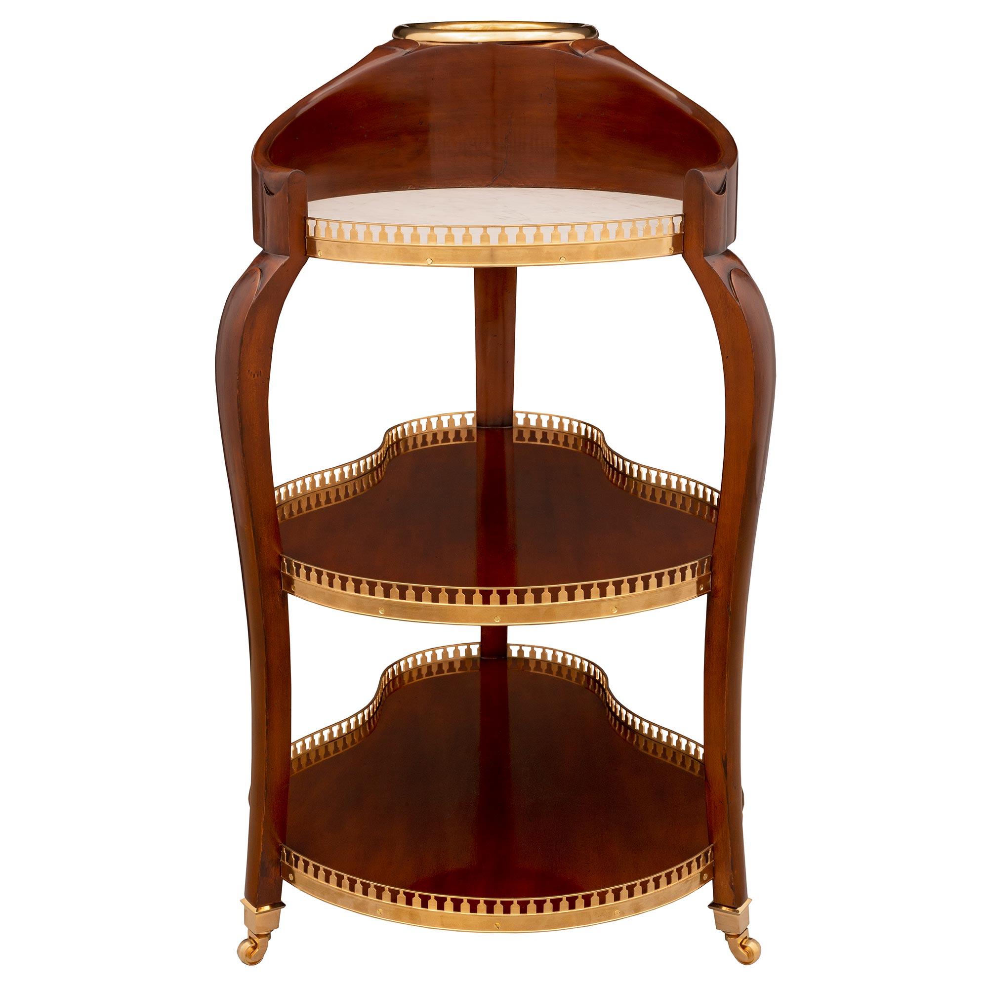 A most elegant and extremely unique French turn of the century Louis XV St. mahogany, ormolu, and white Carrara marble Rafraichissoir side table/bar cart. The bar cart is raised by its original casters below three elegantly curved legs. Each leg is