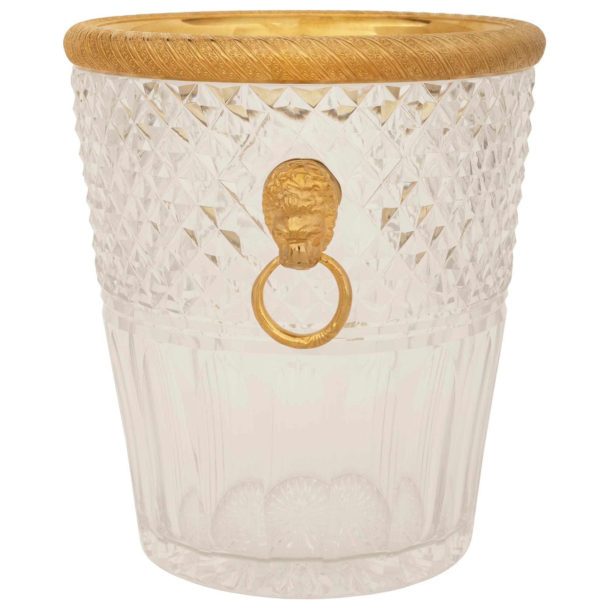 An elegant and high quality French Turn of the Century Louis XVI st. Baccarat Crystal and Ormolu ice bucket. This stunning circular tapered ice bucket displays finely cut fluted designs at the base below two cut bands at the mid section. The body of