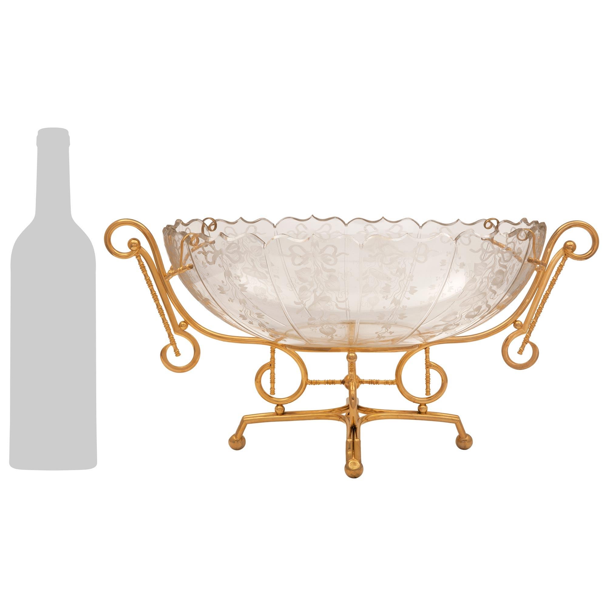 Un bellissimo e decoratissimo set da guarnigione in cristallo acidato e ormolu di fine secolo Luigi XVI. La parure è composta da un centrotavola e due vasi, ciascuno dei quali è sollevato da elegantissimi supporti in ormù con piedi a sfera e superbi